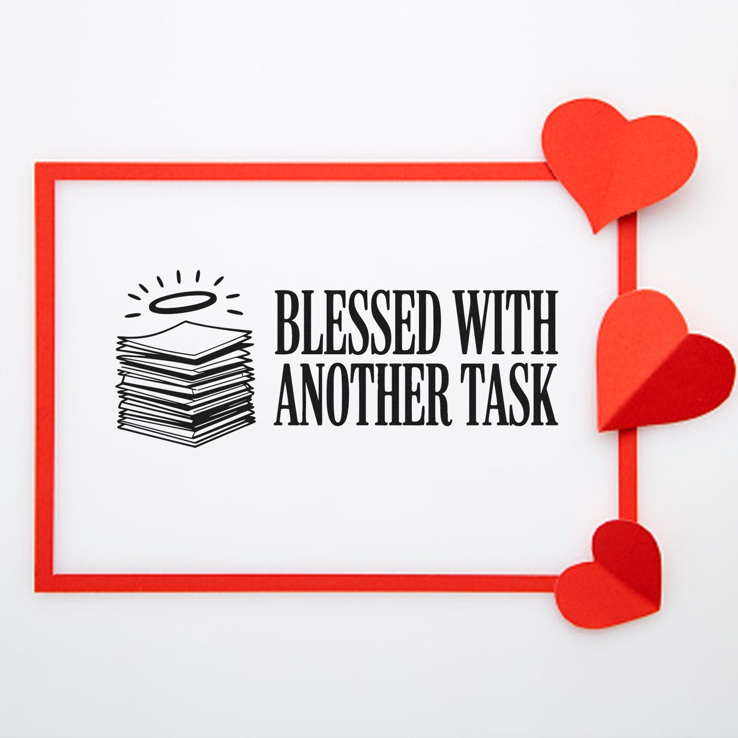 Black stamp and seal reading Blessed With Another Task with stack-and-halo icon, red border, and heart accents.