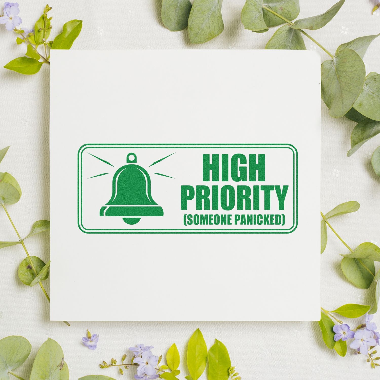 Green high priority bell stamp seal on white card, framed by green leaves and small purple flowers.