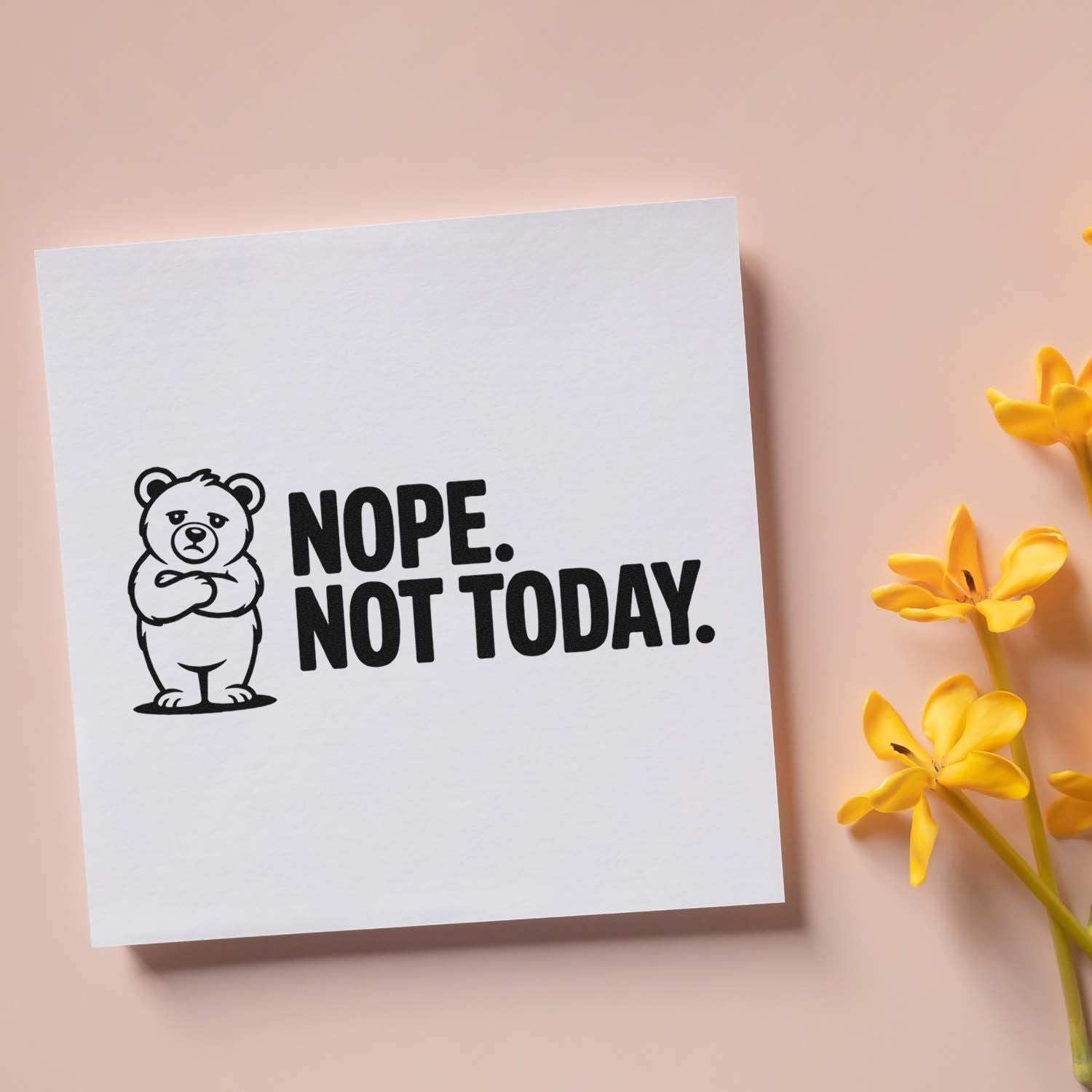 Black bear stamp/seal with NOPE. NOT TODAY. in black on white paper, beside yellow flowers on blush pink.