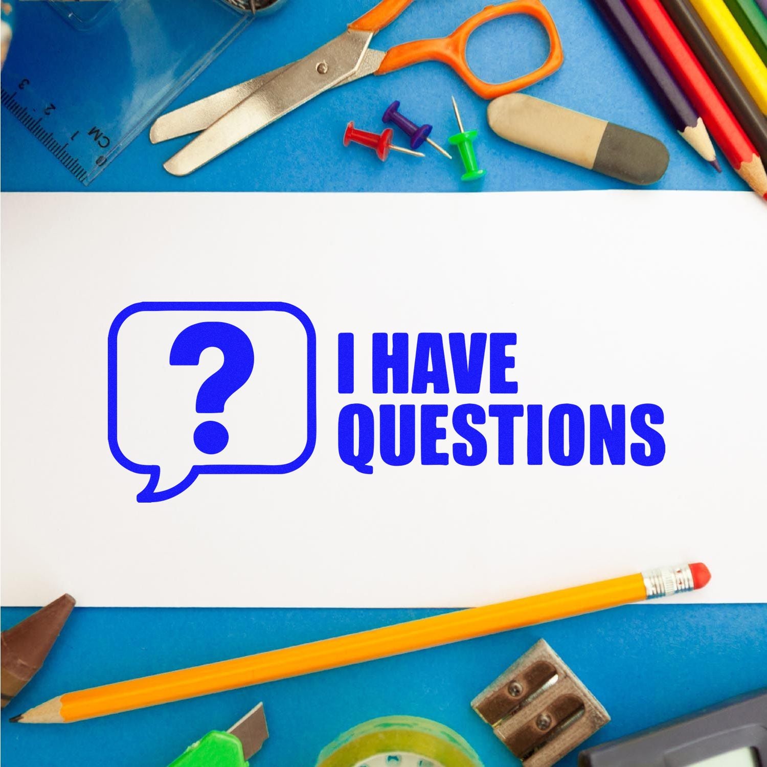 Blue self-inking stamp seal reading I HAVE QUESTIONS on white paper, with colorful school supplies on a blue background.