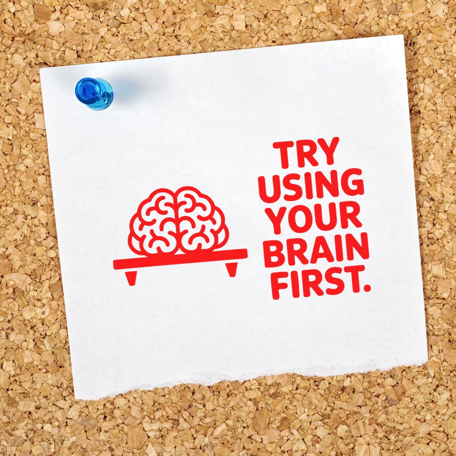 Red rubber stamp with brain icon and Try using your brain first on white paper, pinned to corkboard with a blue seal.