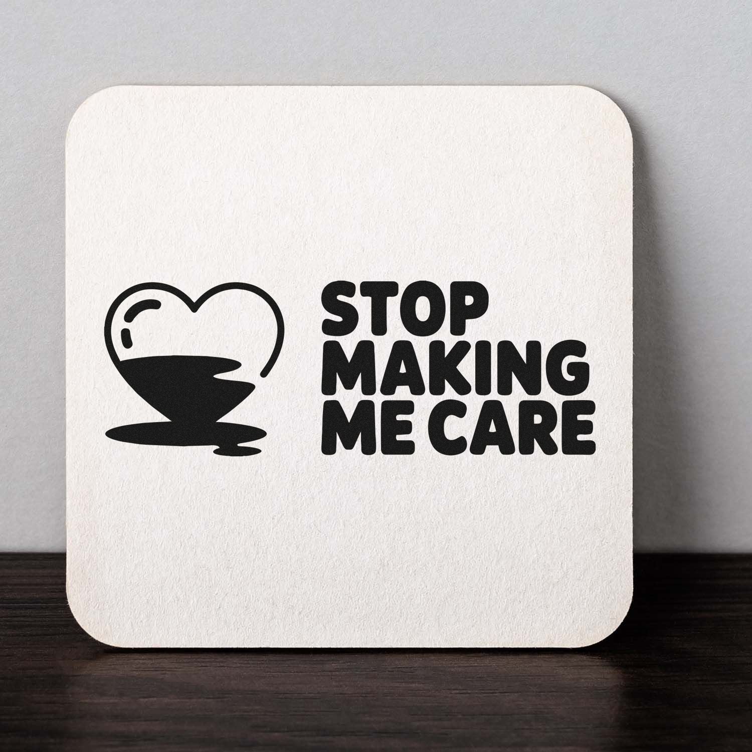 Black rubber stamp seal on white square: broken heart icon and bold STOP MAKING ME CARE text.