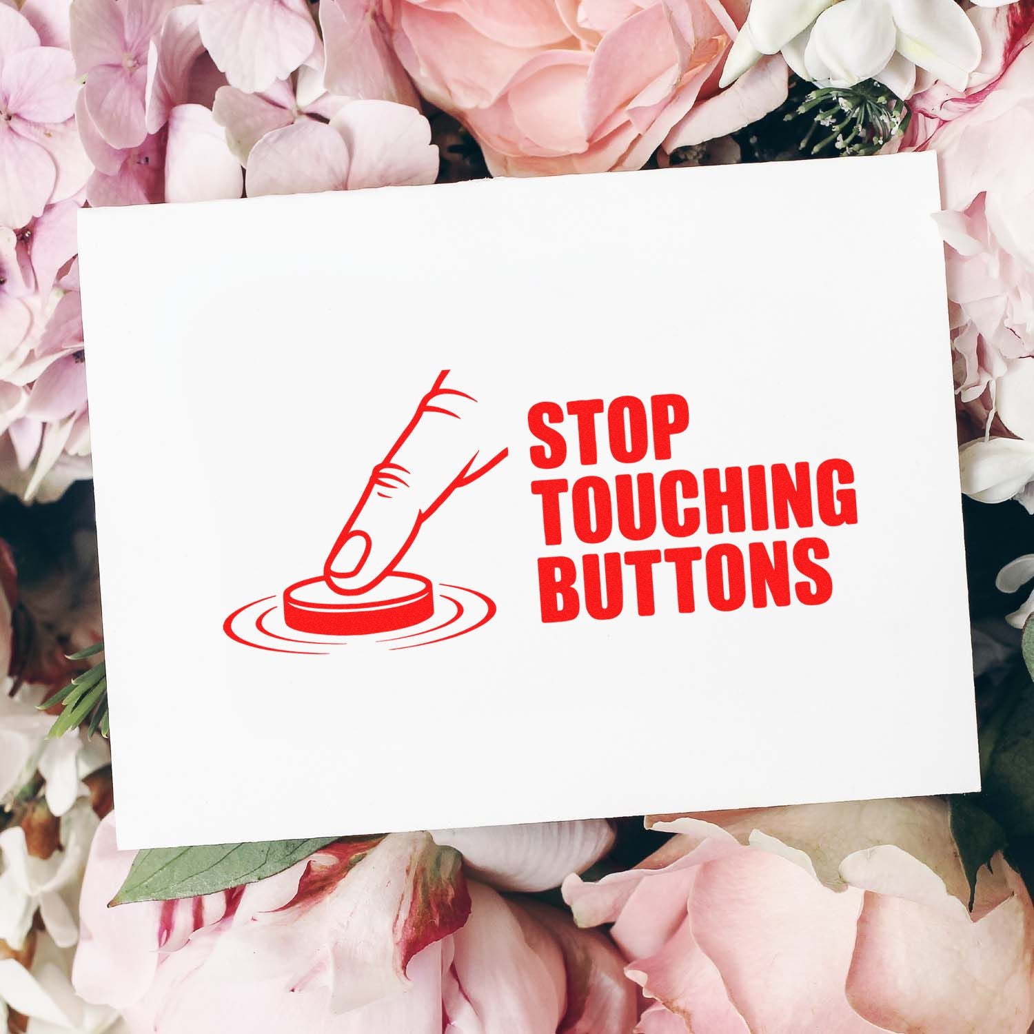Red rubber stamp and seal reading Stop Touching Buttons on a white card, framed by pink and white flowers.