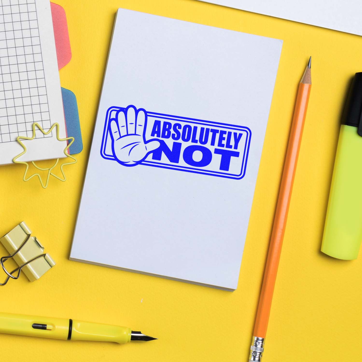 Blue Absolutely Not rubber stamp seal with hand icon on white paper, set on a yellow stationery desk.