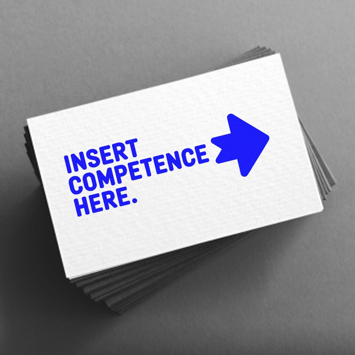 Blue Insert Competence Here stamp design with arrow on white seal card stack against a gray background.