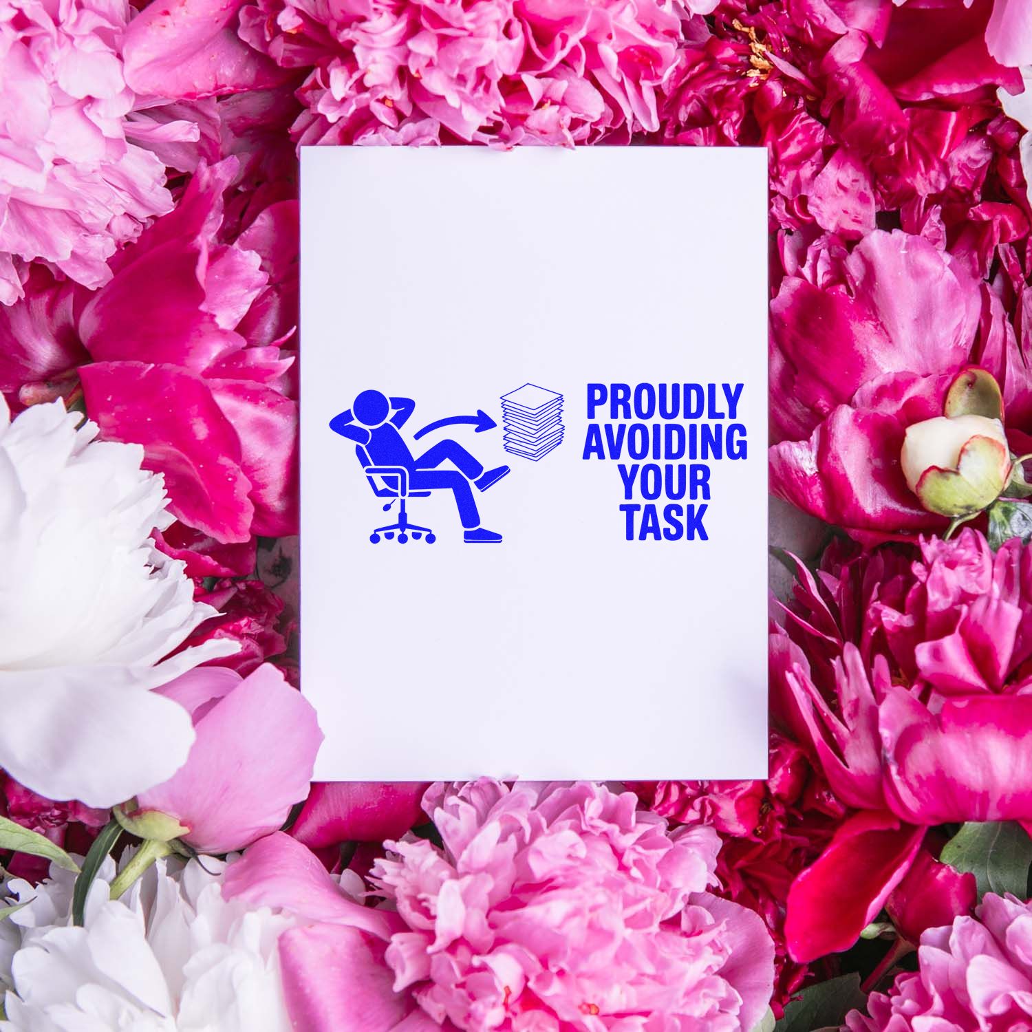 Blue custom stamp seal on white card reading Proudly Avoiding Your Task, surrounded by pink and white flowers.