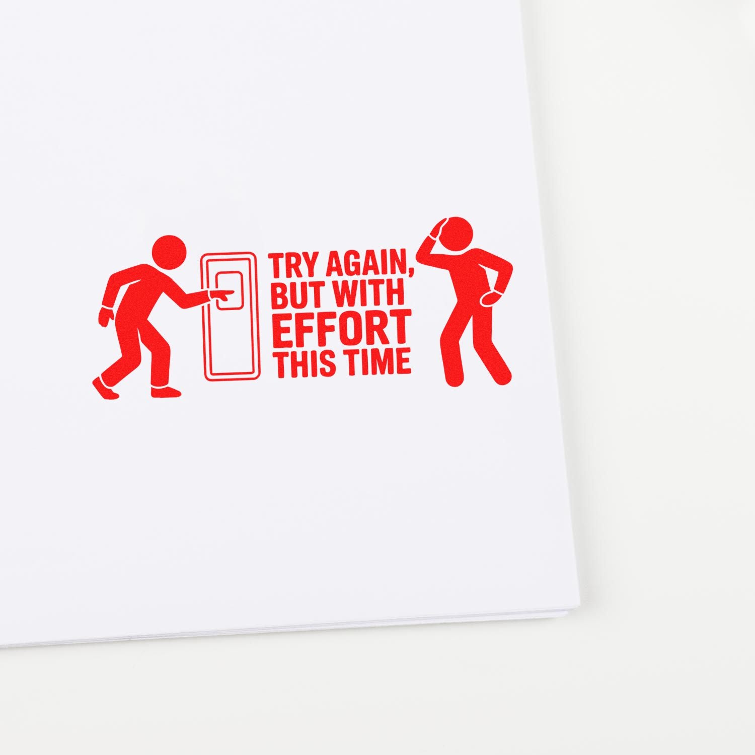 Red motivational stamp seal reading Try Again, But With Effort This Time with two red figures on white paper.