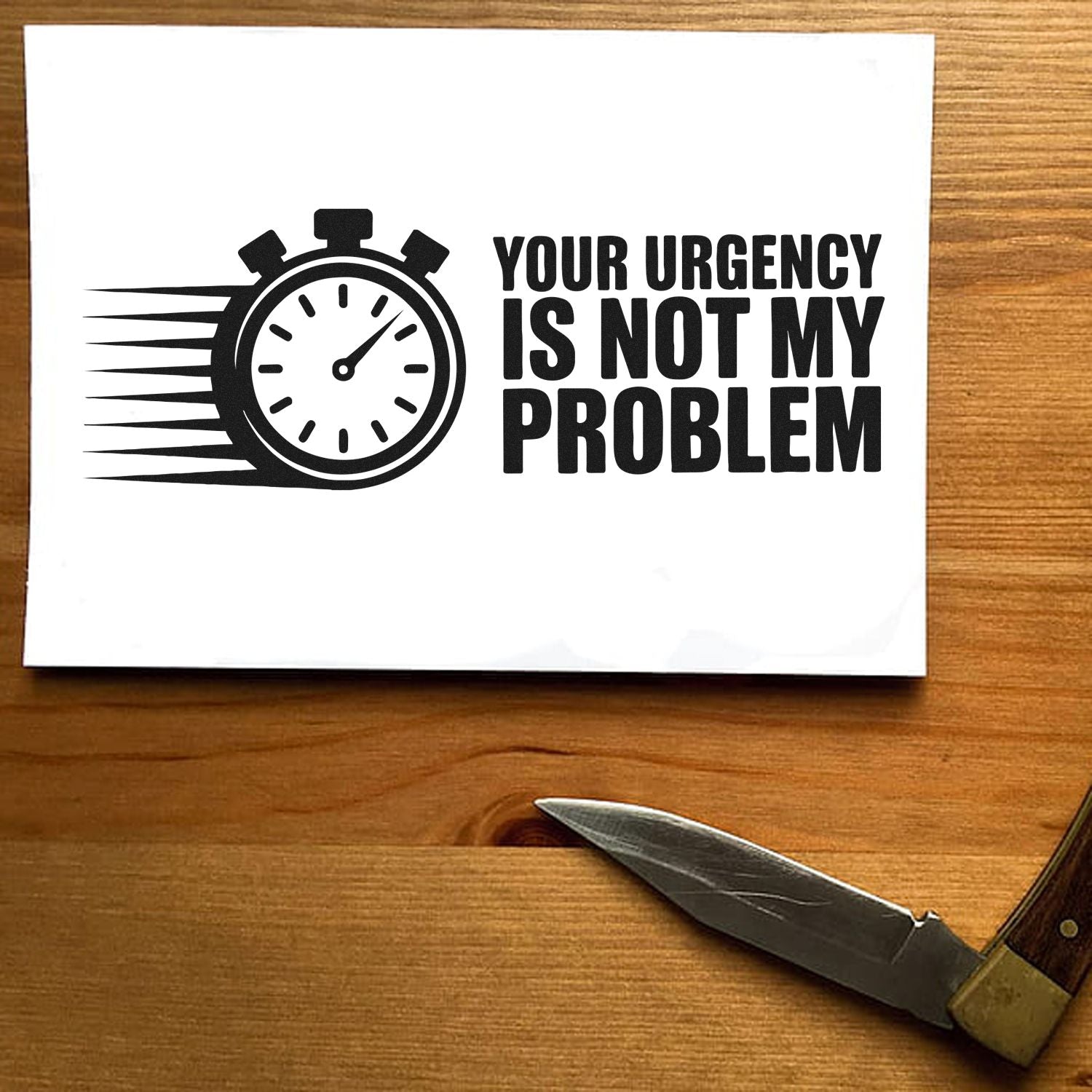 Black urgency stamp seal design with stopwatch icon and bold text on white paper, on a wood table.