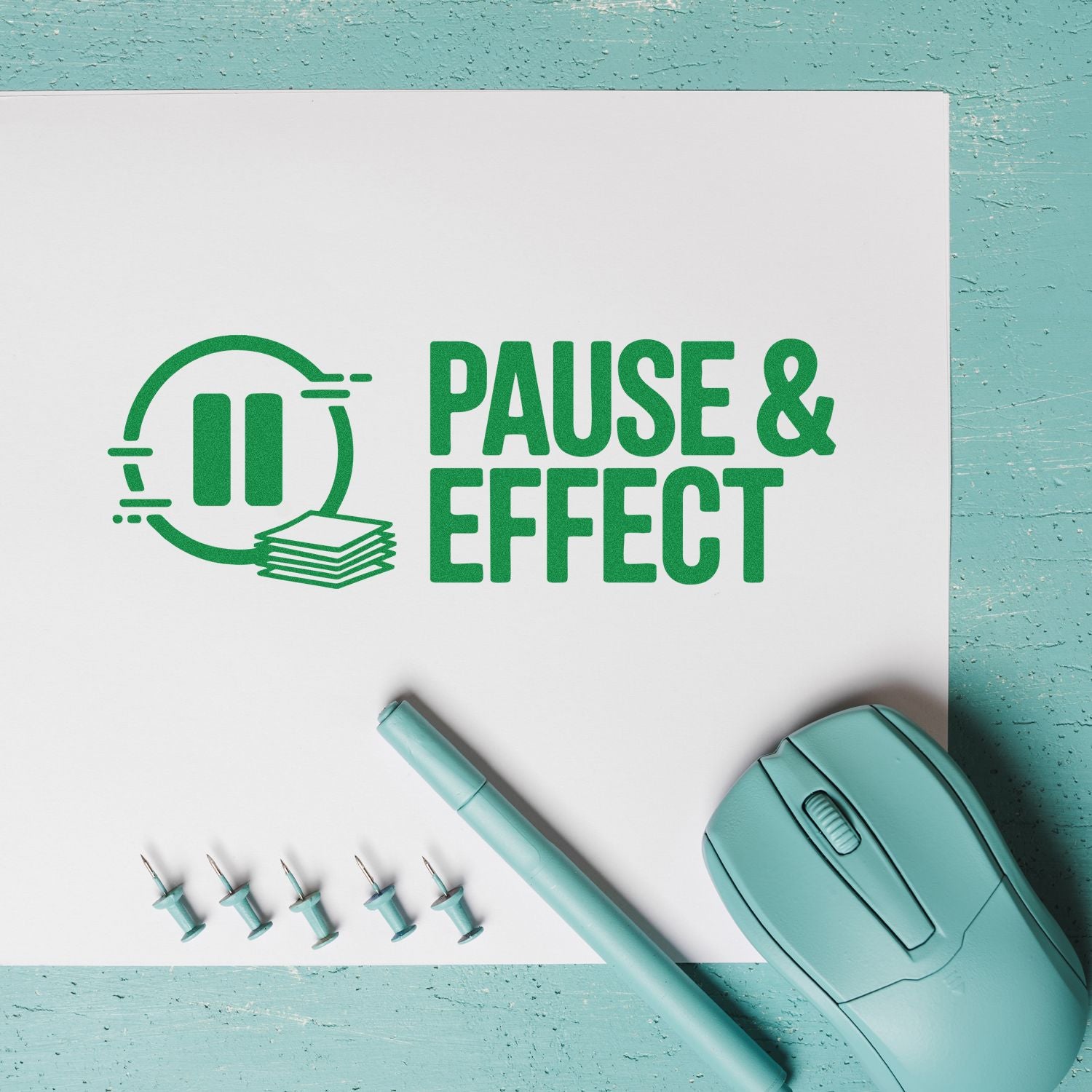 Green PAUSE & EFFECT stamp design on white paper with aqua stamp pen, seal tool, and mouse on teal background.