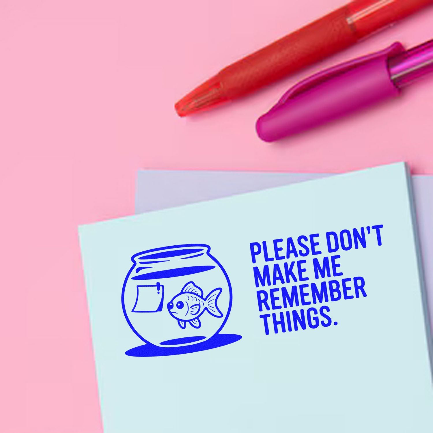 Pink background with red and magenta stamp/seal pens beside a blue card stamped with fishbowl and Please dont make me remember things.