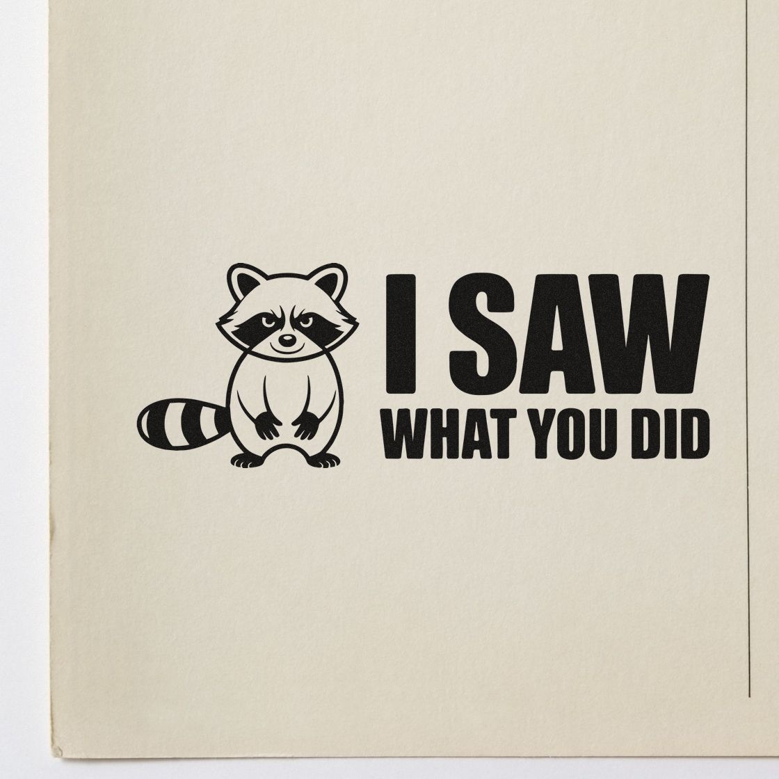 Black stamp seal with raccoon graphic and bold I SAW WHAT YOU DID text on cream paper.