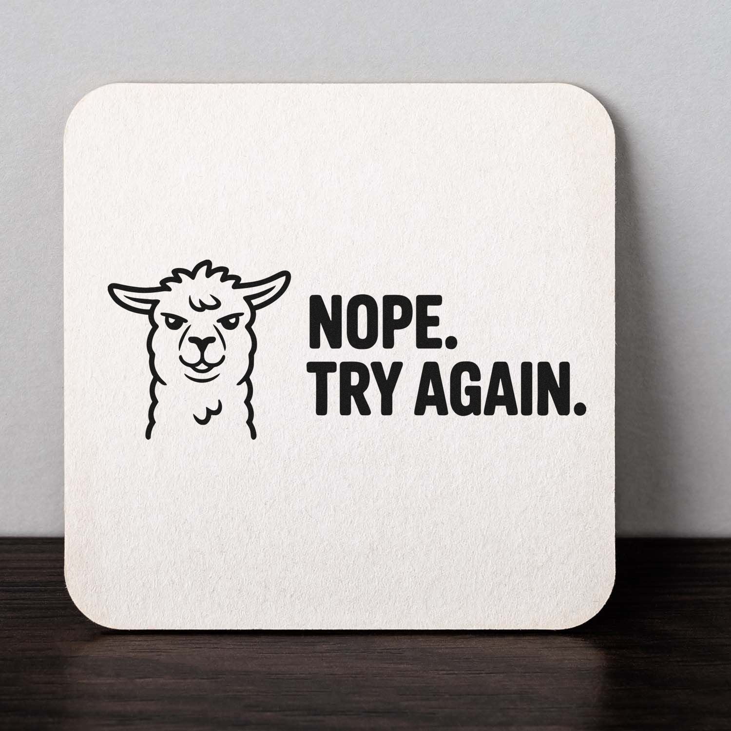 White stamp seal with black llama graphic and bold text reading NOPE. TRY AGAIN. on a cream square base.
