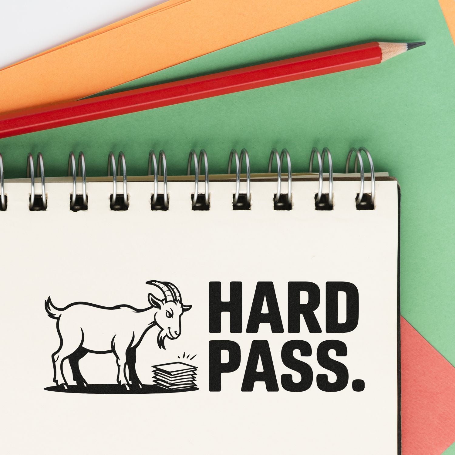 Hard Pass stamp and seal design on spiral notebook, with black goat icon, red pencil, and green, orange, red paper.