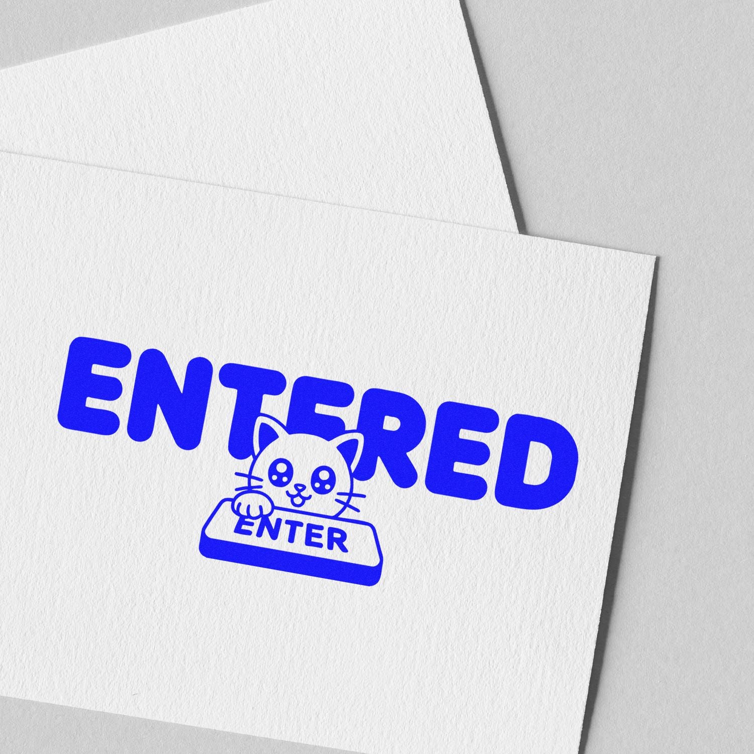 Blue ENTERED cat stamp and seal on white textured paper with envelope, showcasing custom stamp and seal products.