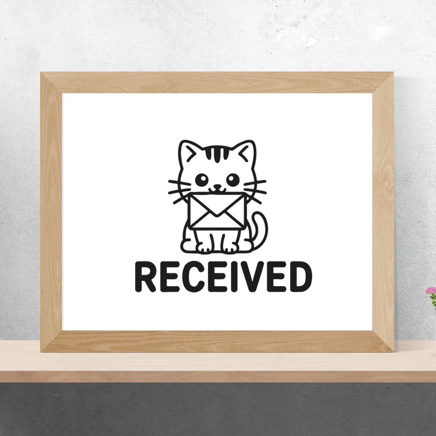 Black received stamp/seal design with a cat holding an envelope, displayed in a light wood frame.