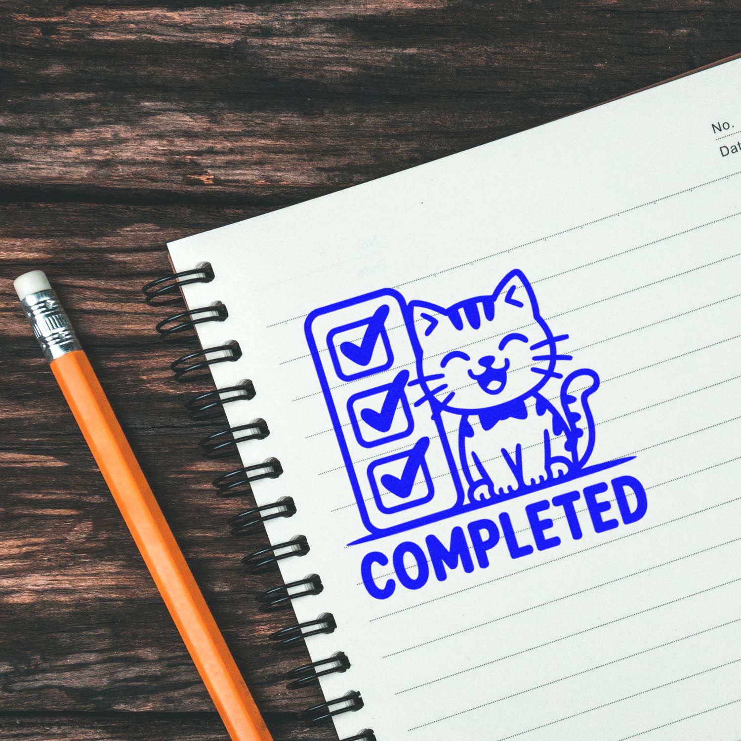 Blue completed stamp seal with checklist and cat on lined notebook, beside an orange pencil on dark wood.
