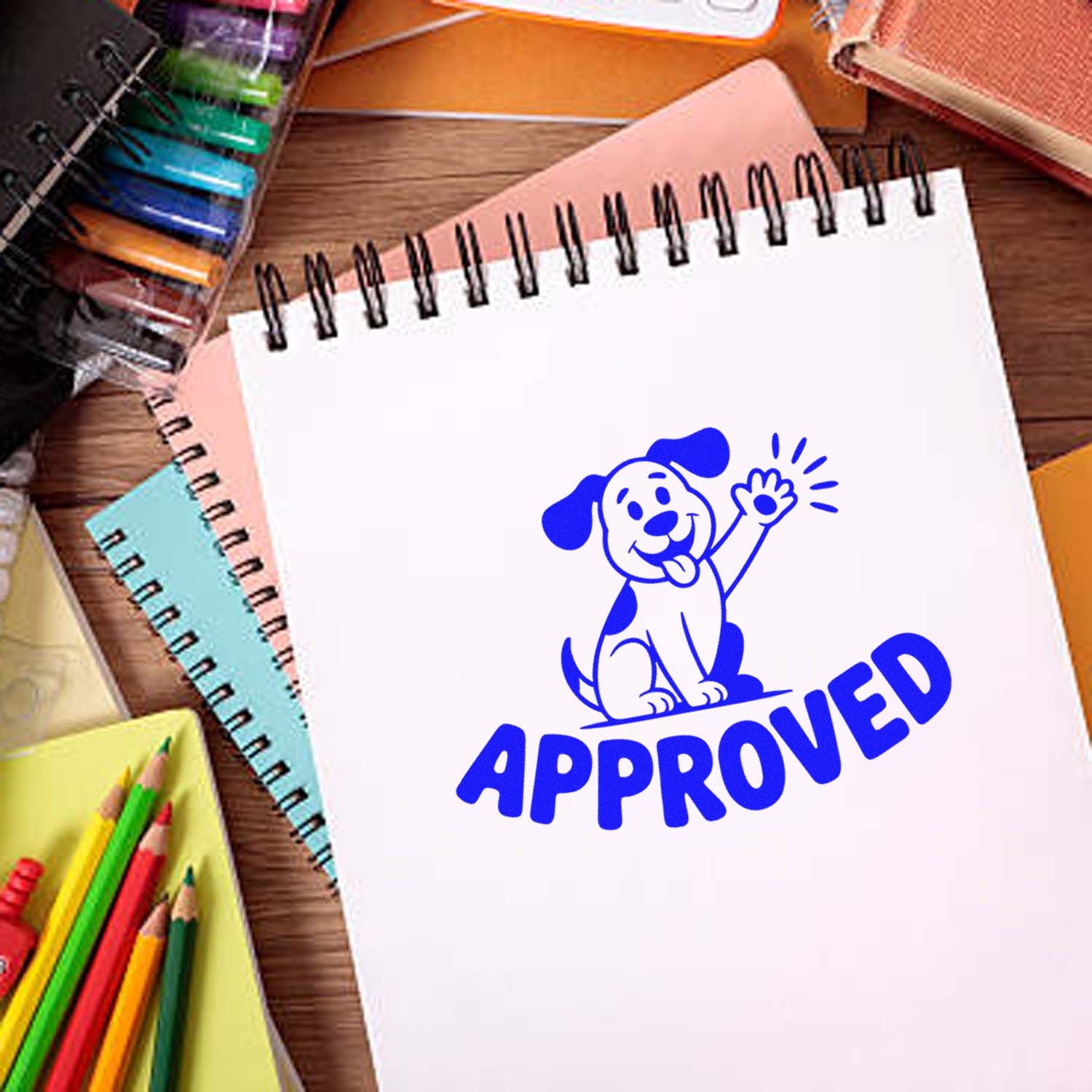 Blue approved stamp seal with waving dog on white spiral notebook, surrounded by colorful notebooks and pencils.