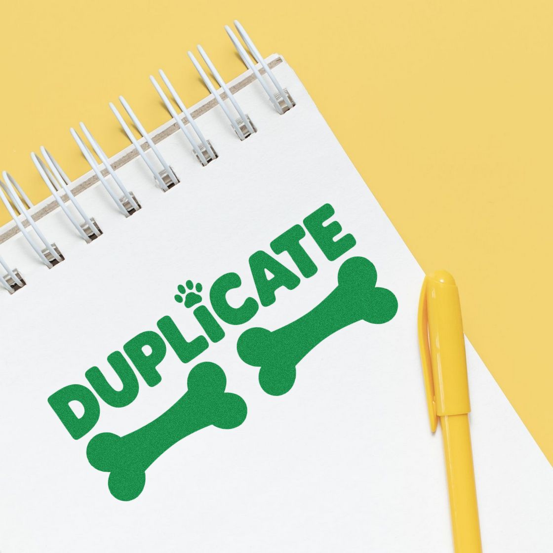Green duplicate stamp and seal graphic with bone icons on a white notepad, beside a yellow pen on a yellow background.