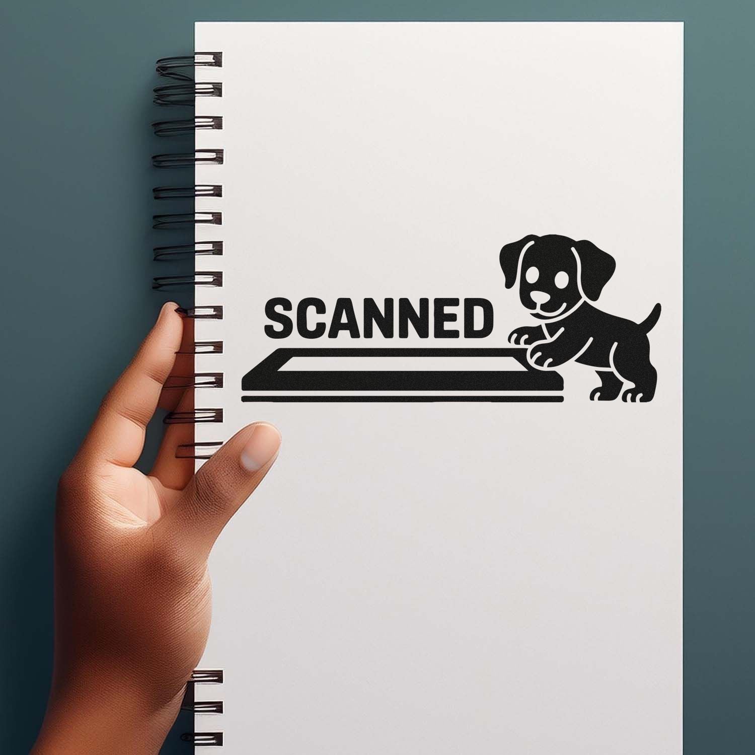 Black SCANNED stamp and seal with puppy and scanner icon on a white spiral notebook against a teal background.