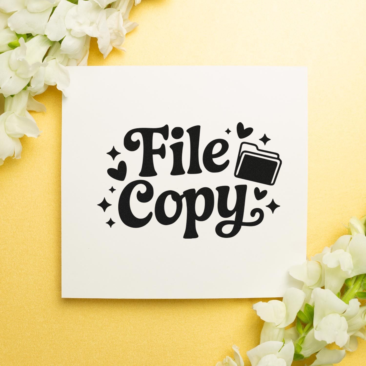 Black File Copy stamp and seal design with folder icon, hearts, and sparkles on a white card over a yellow background with white flowers.