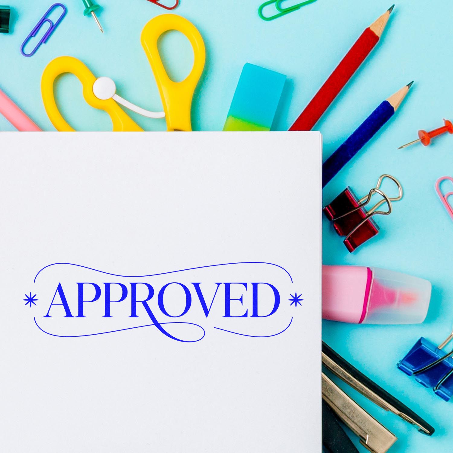 White sheet with blue APPROVED stamp, surrounded by colorful stamp and seal supplies, pencils, clips, and eraser on turquoise.