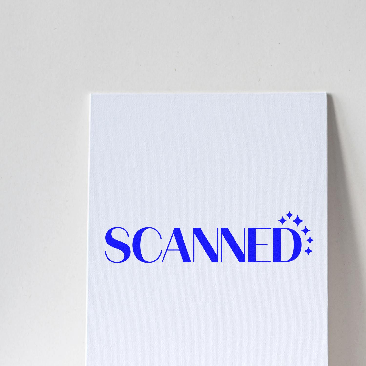 White textured paper stamp seal with blue SCANNED text and sparkle icons.