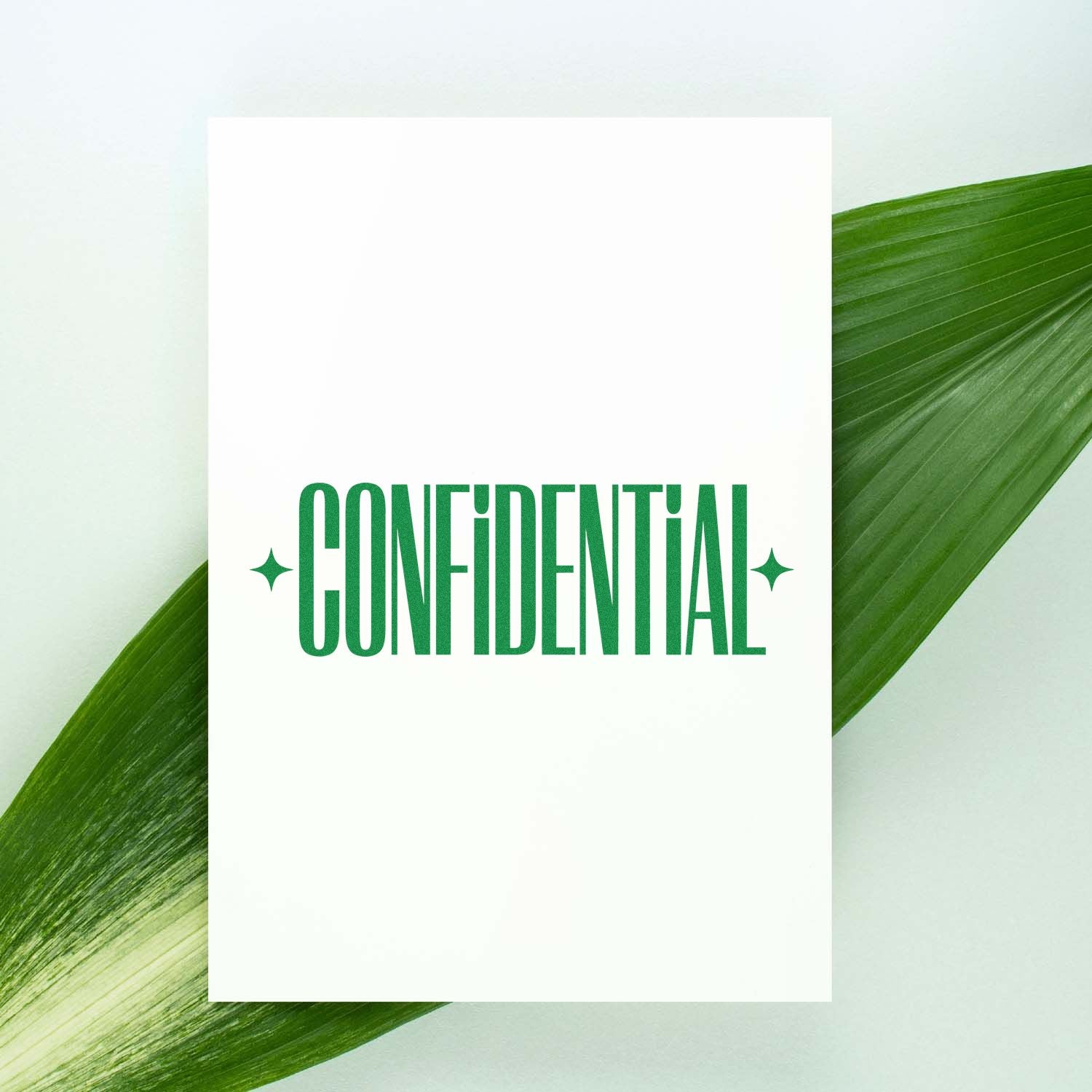 Green CONFIDENTIAL stamp and seal on a white card with a leafy green background.