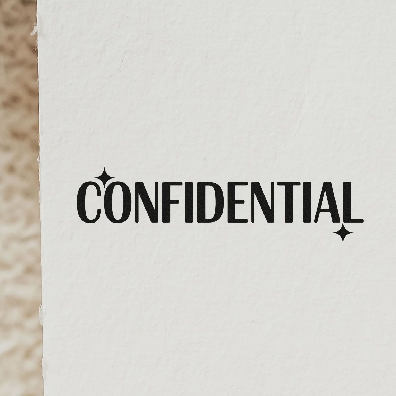 Black CONFIDENTIAL rubber stamp seal on white paper with sparkle accents