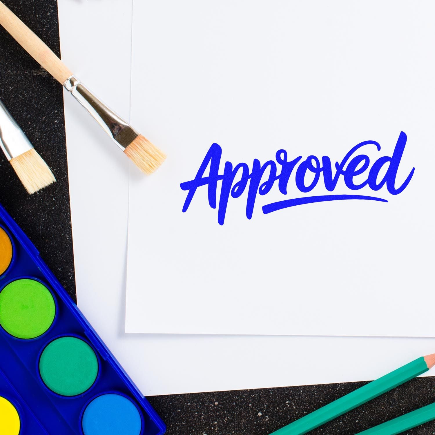 Blue Approved seal on white paper, with paintbrushes, colored pencils, and watercolor paints.