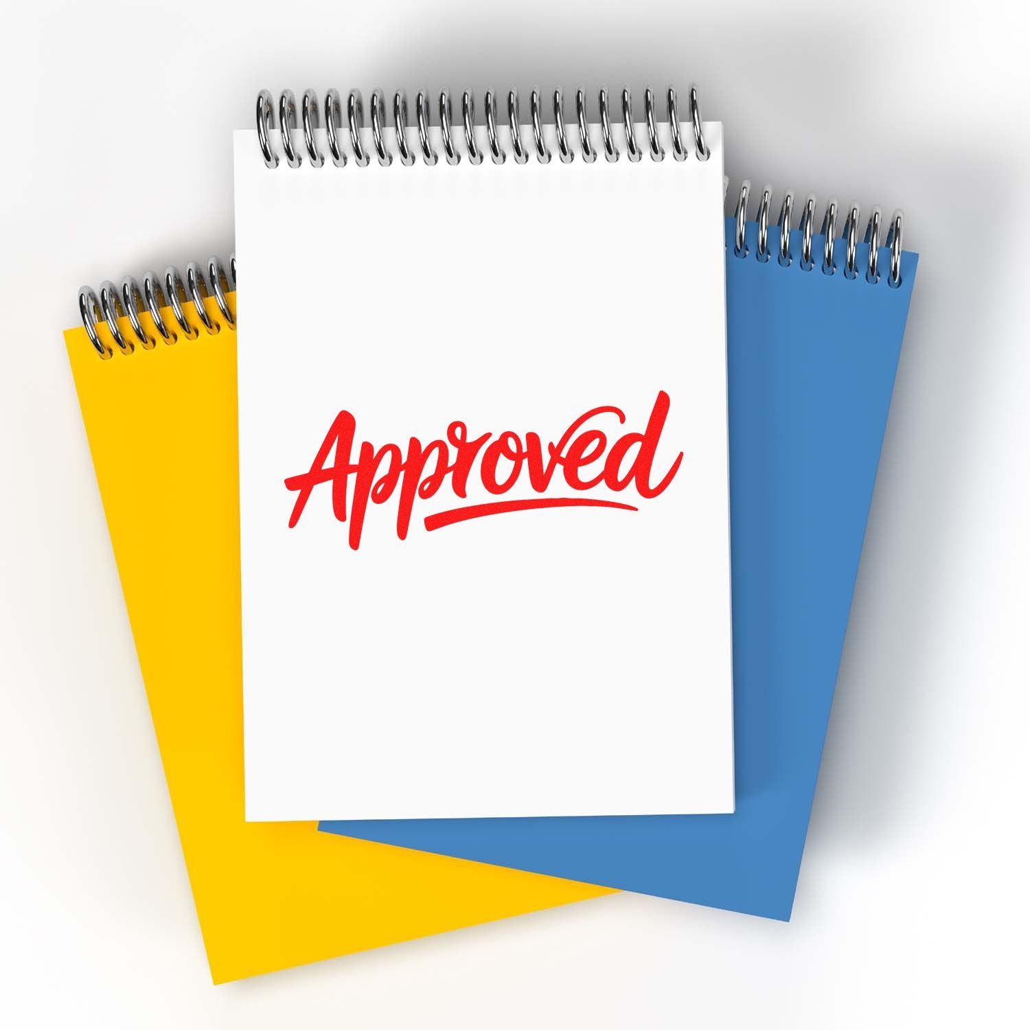 White spiral notepad with red Approved stamp, layered over yellow and blue notepads for stamp and seal products.