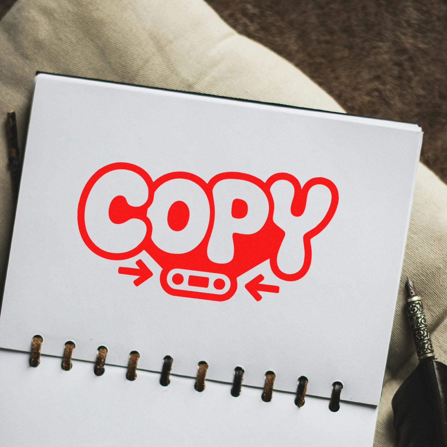 Red COPY stamp and seal logo on a white spiral-bound notebook page, with arrows and an oval seal icon.