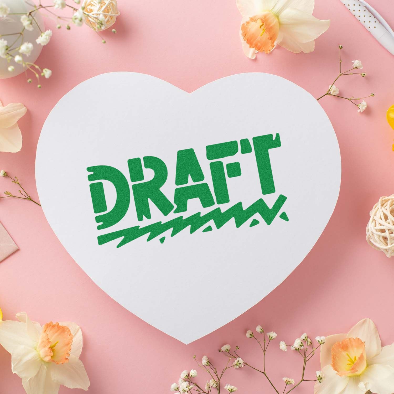 White heart-shaped draft stamp seal with green text on a pink background, surrounded by daffodils and baby's breath.