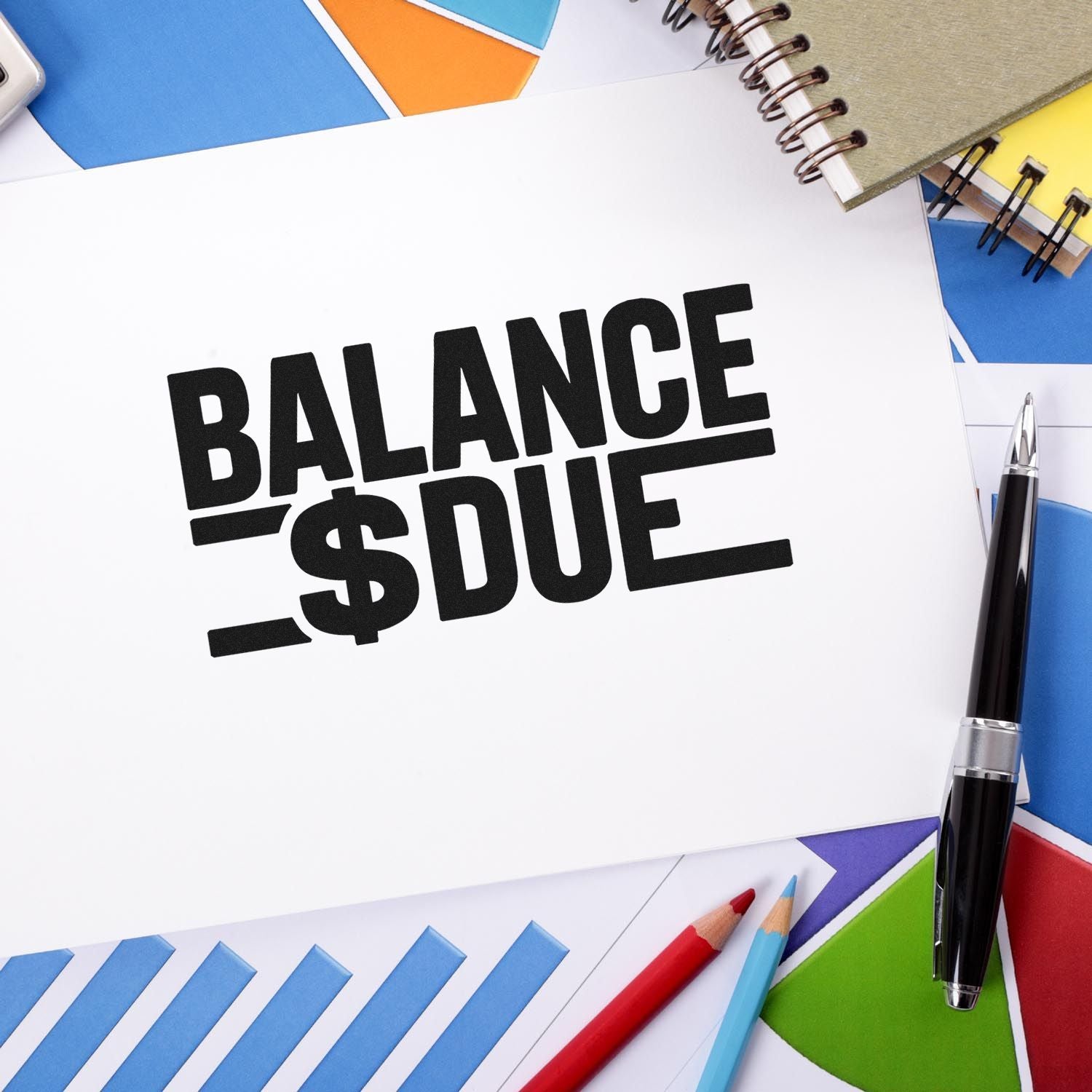 Black Balance Due stamp and seal on white paper, with colorful envelopes, notebook, and pen.