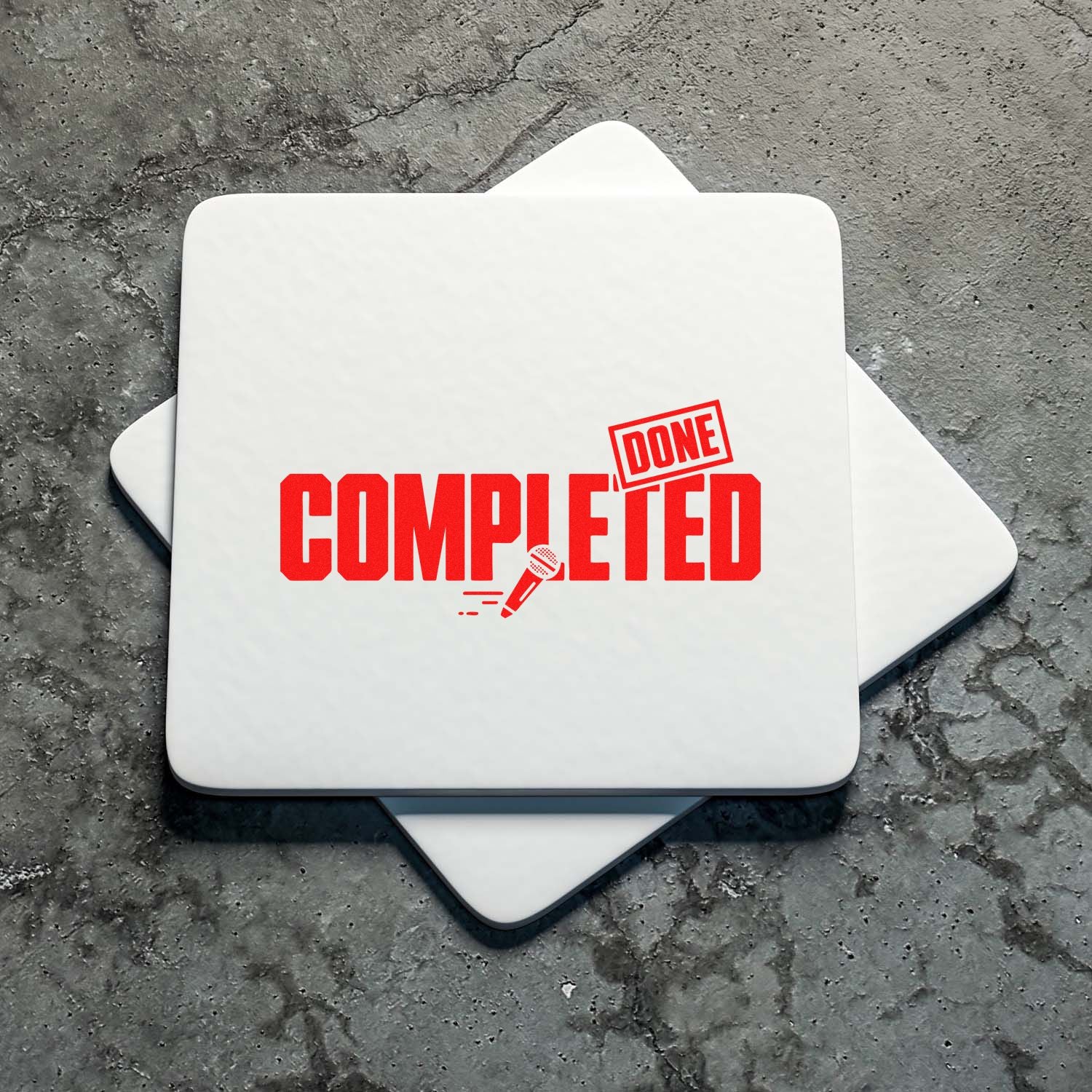 White stamp and seal pads with bold red COMPLETED and DONE imprint on a gray concrete background.