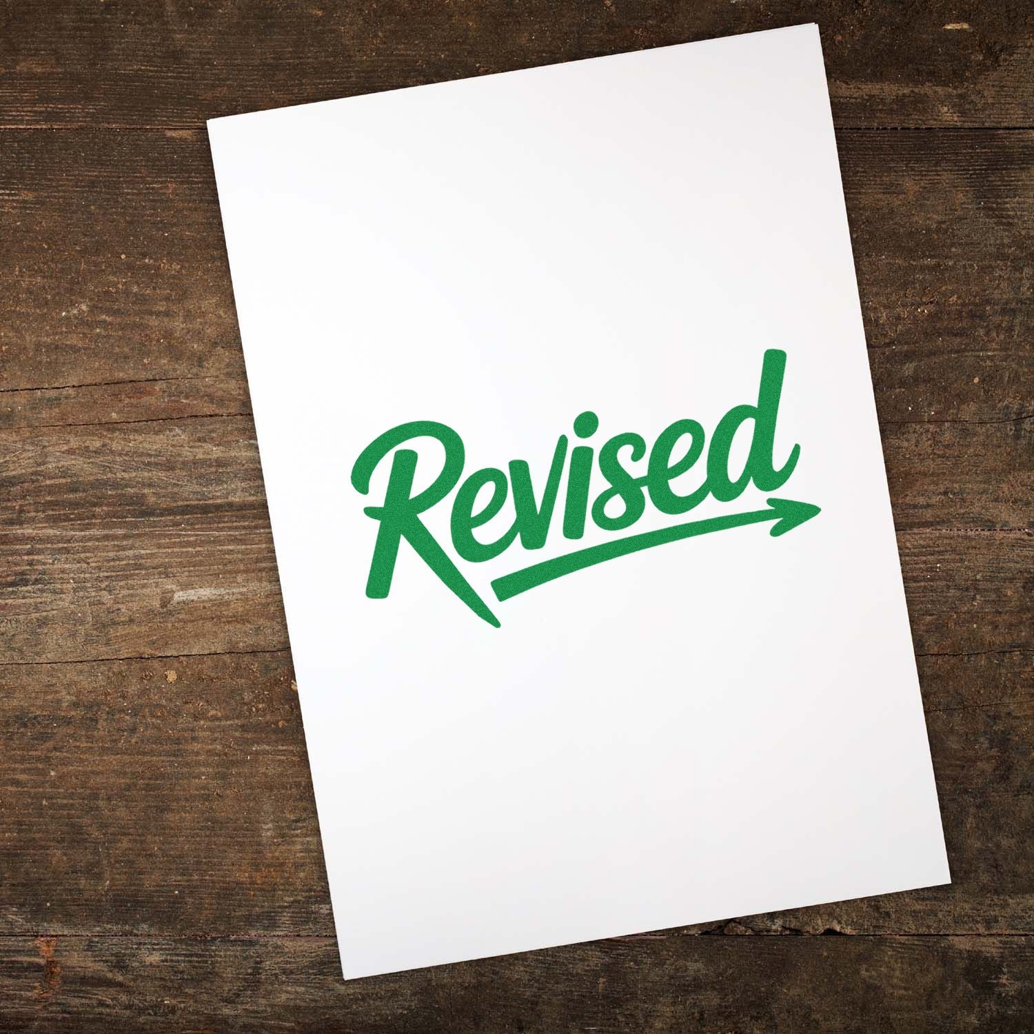 White sheet with green Revised stamp seal on a rustic wood background
