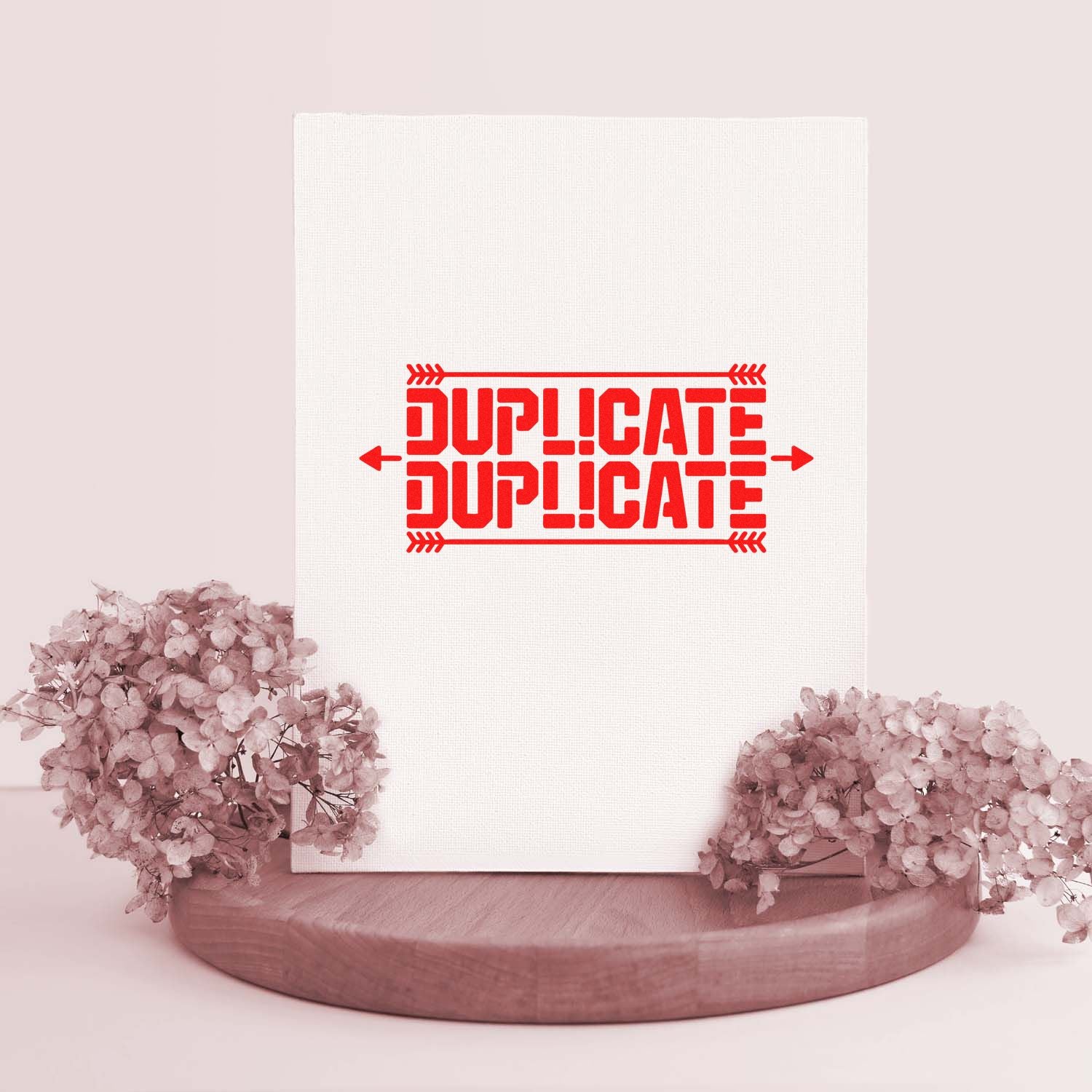White textured display with bold red DUPLICATE stamp seal, framed by soft pink flowers on a wooden base.