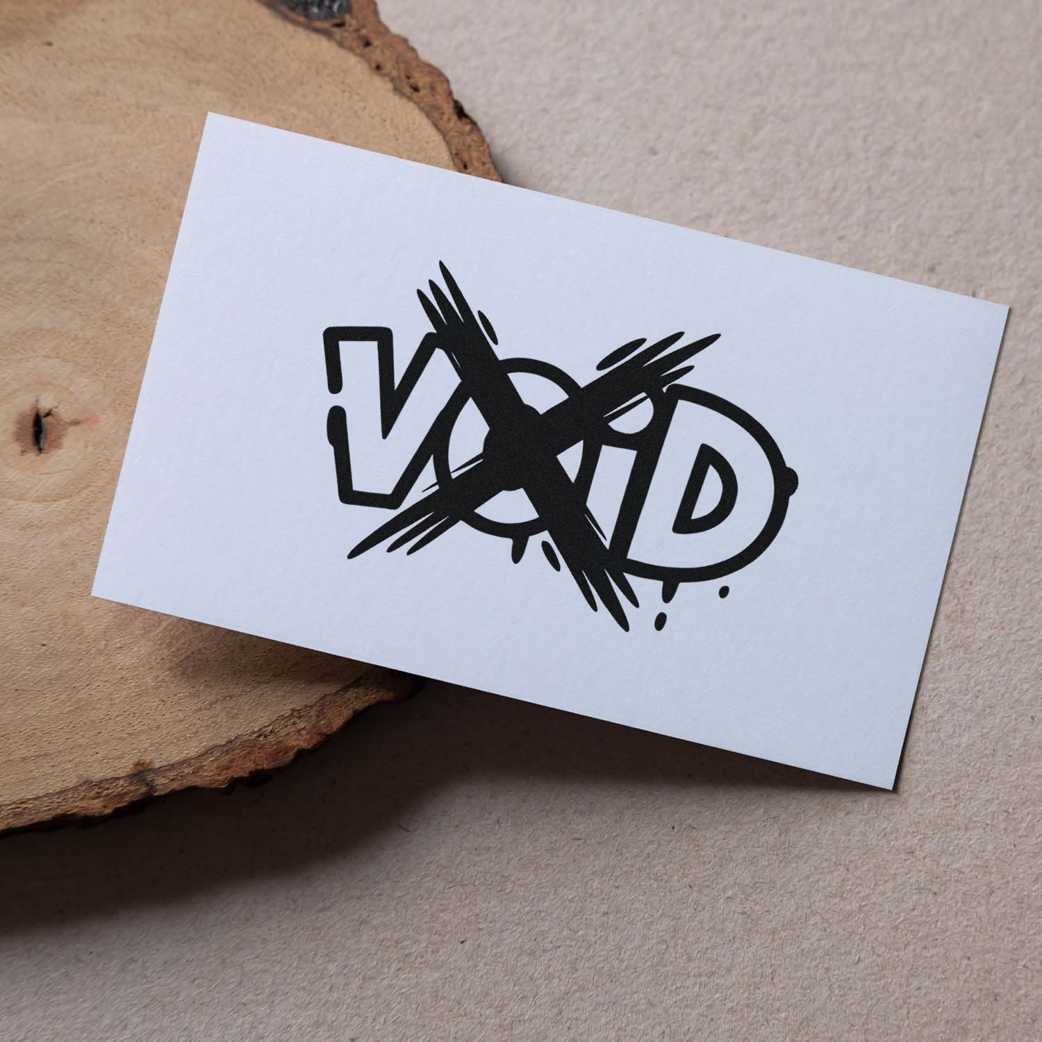 Black VOID security stamp seal on white card, crossed out with bold brush marks on a tan textured background.