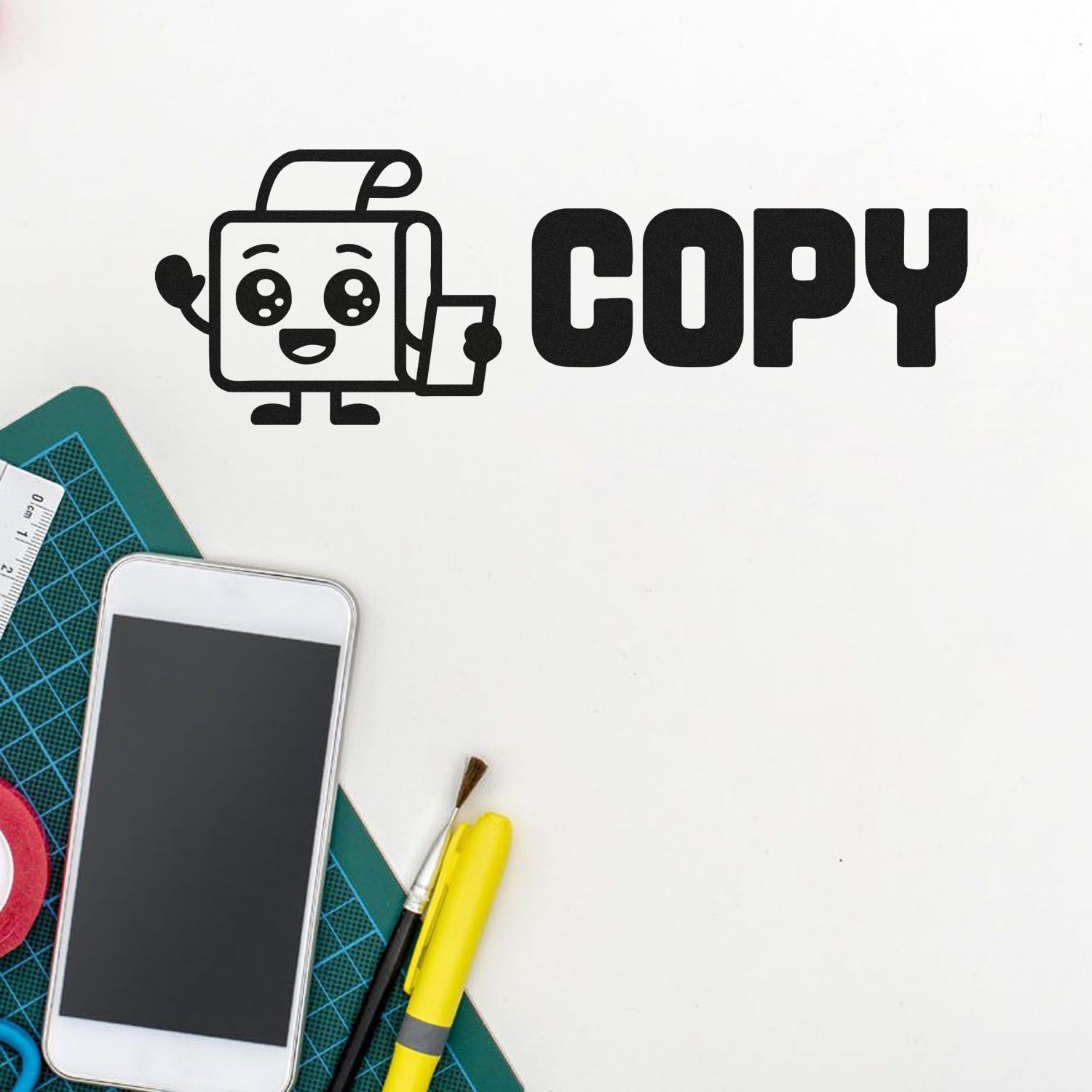 Black COPY stamp seal with cartoon document icon on white background, beside cutting mat, smartphone and yellow craft tools.