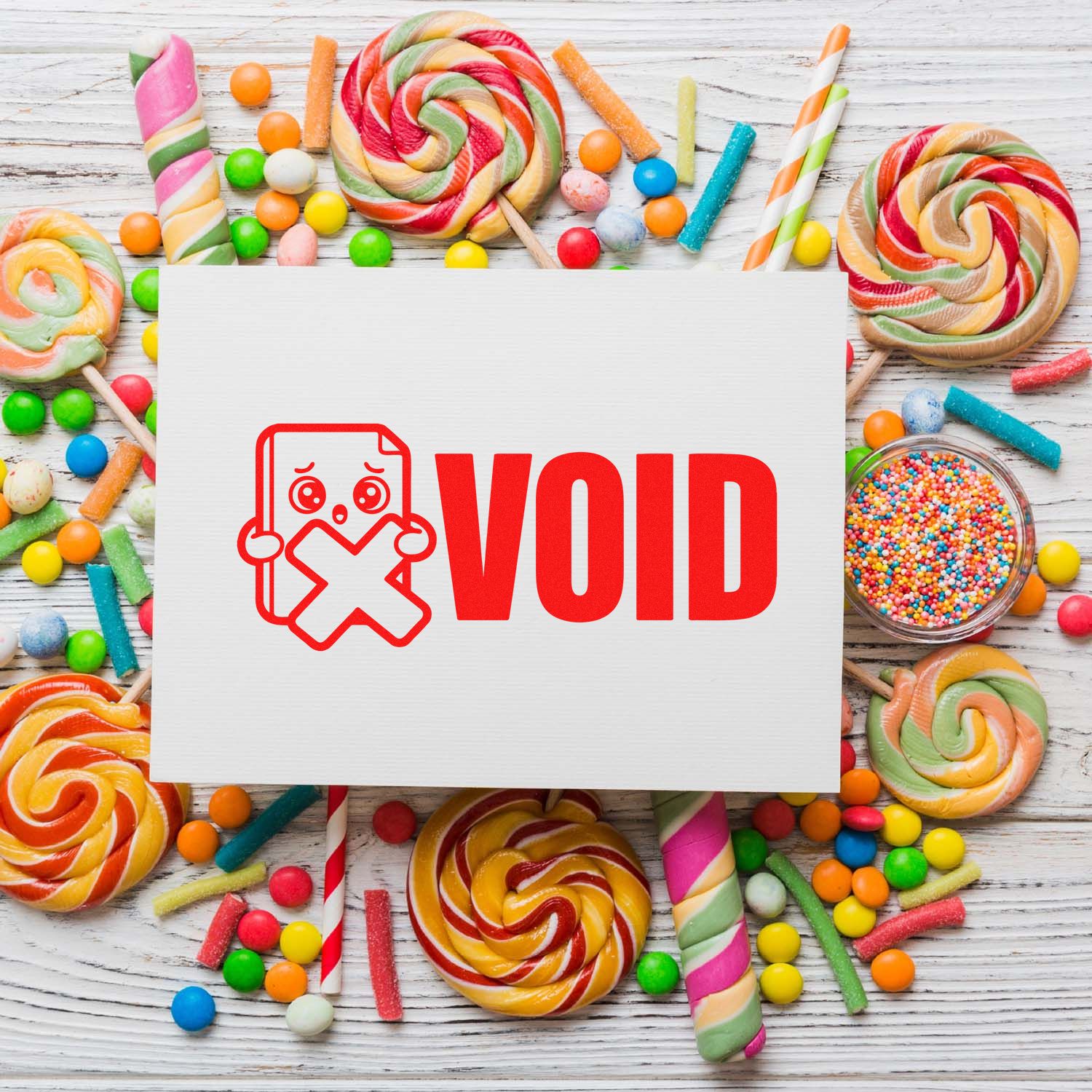 Red VOID stamp and seal on white card, surrounded by colorful lollipops and candy sprinkles.