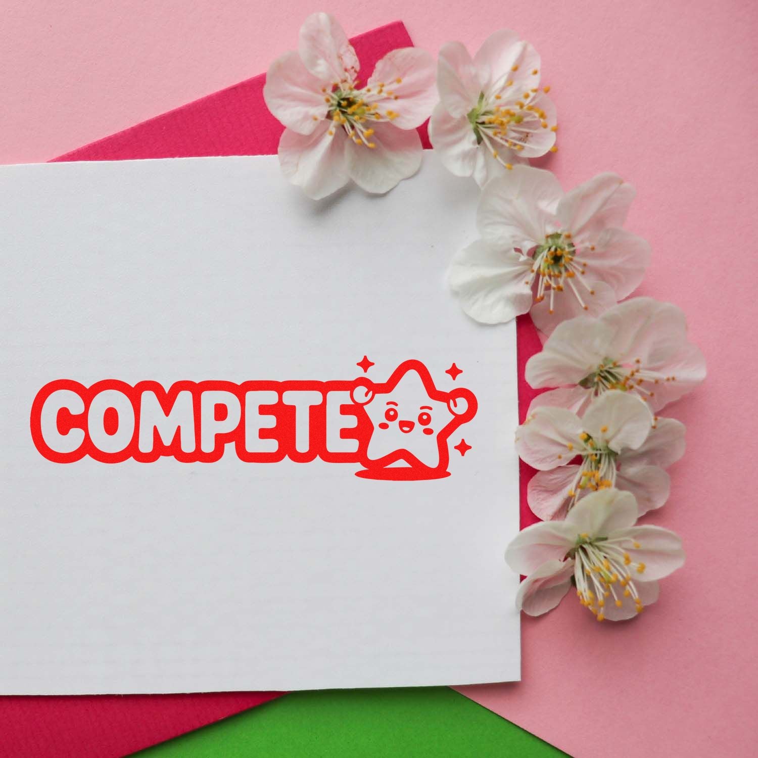 Custom stamp and seal with red COMPETE star logo on white card, framed by pale pink cherry blossoms on a pink background.
