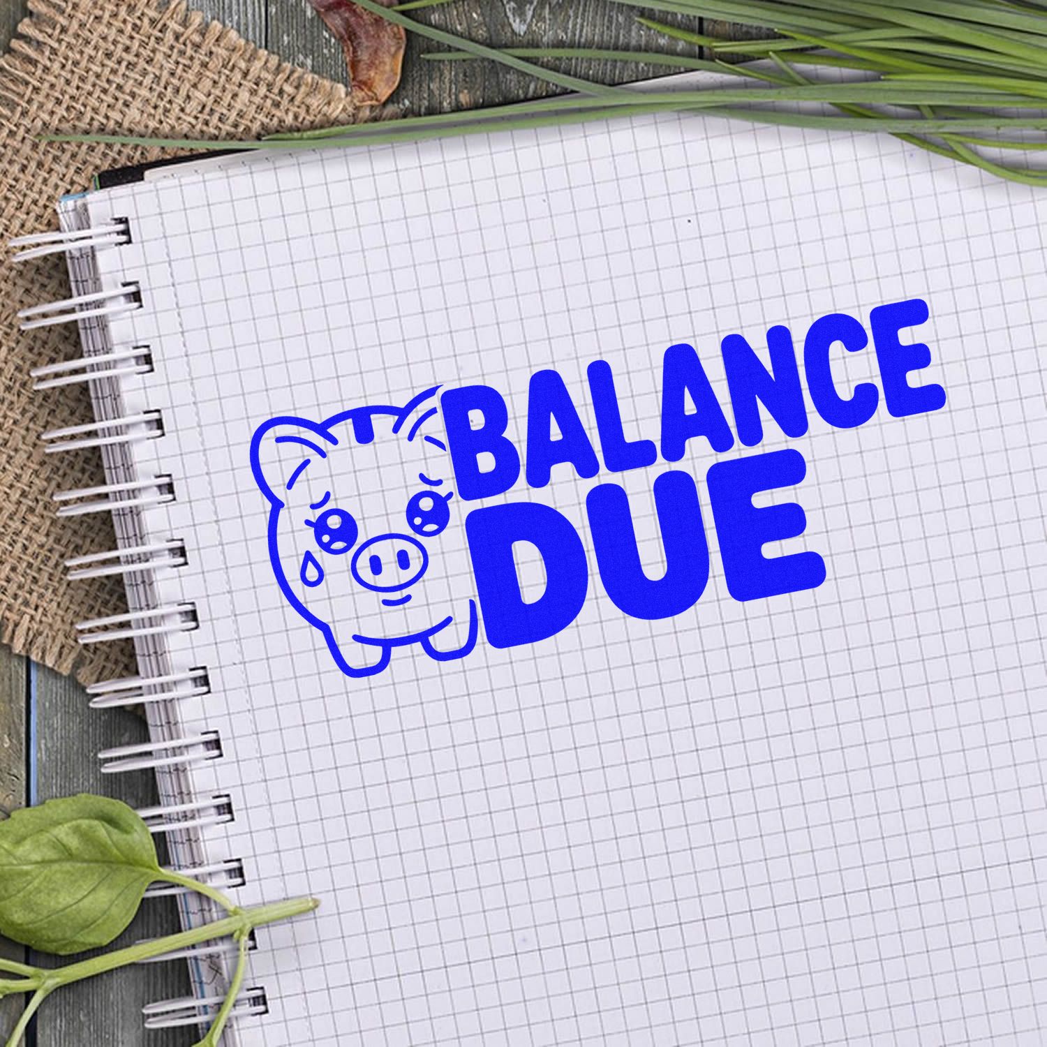 Blue balance due stamp seal with pig icon on grid notebook paper.