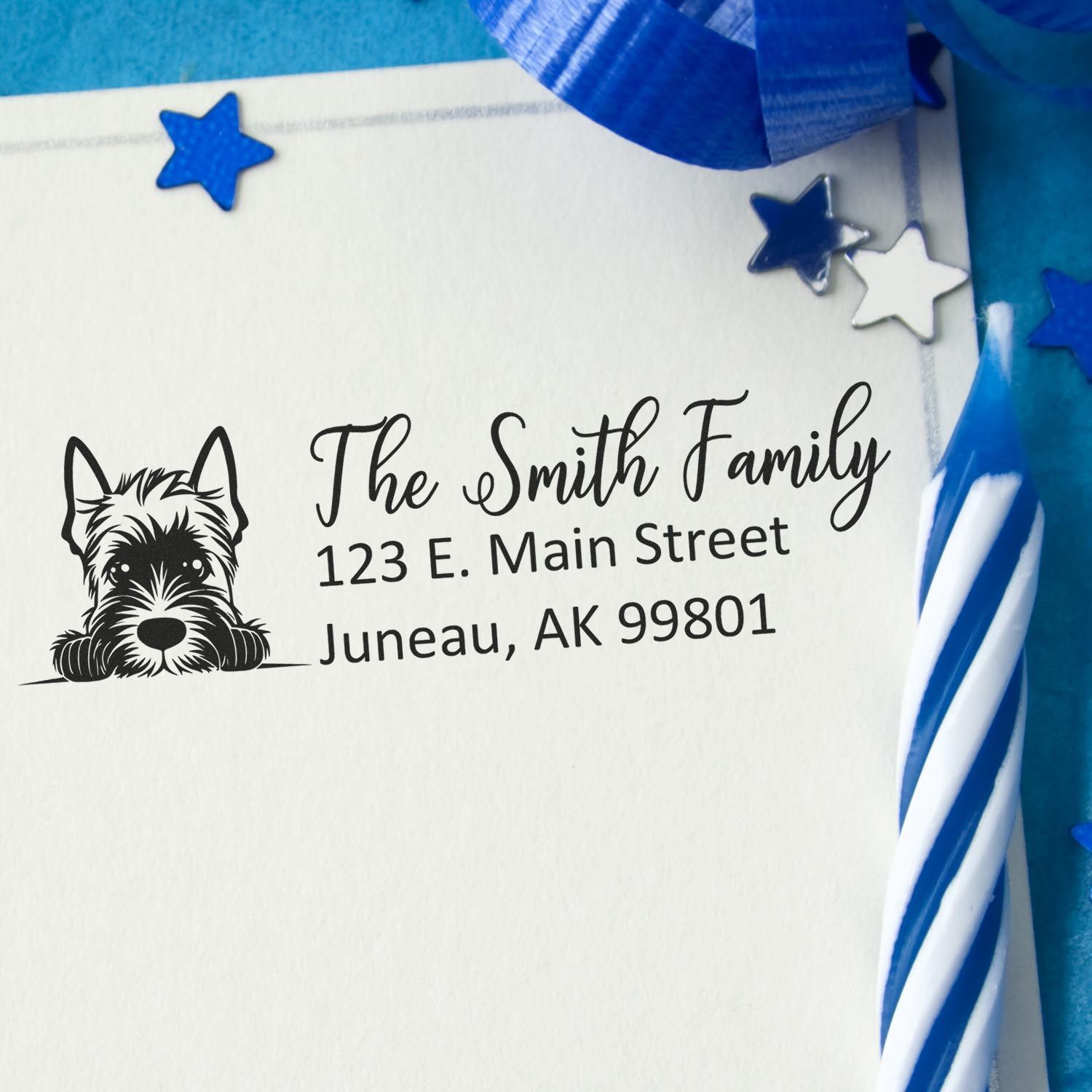 Custom black family address stamp with dog icon on white paper, surrounded by blue ribbon and star seal accents.