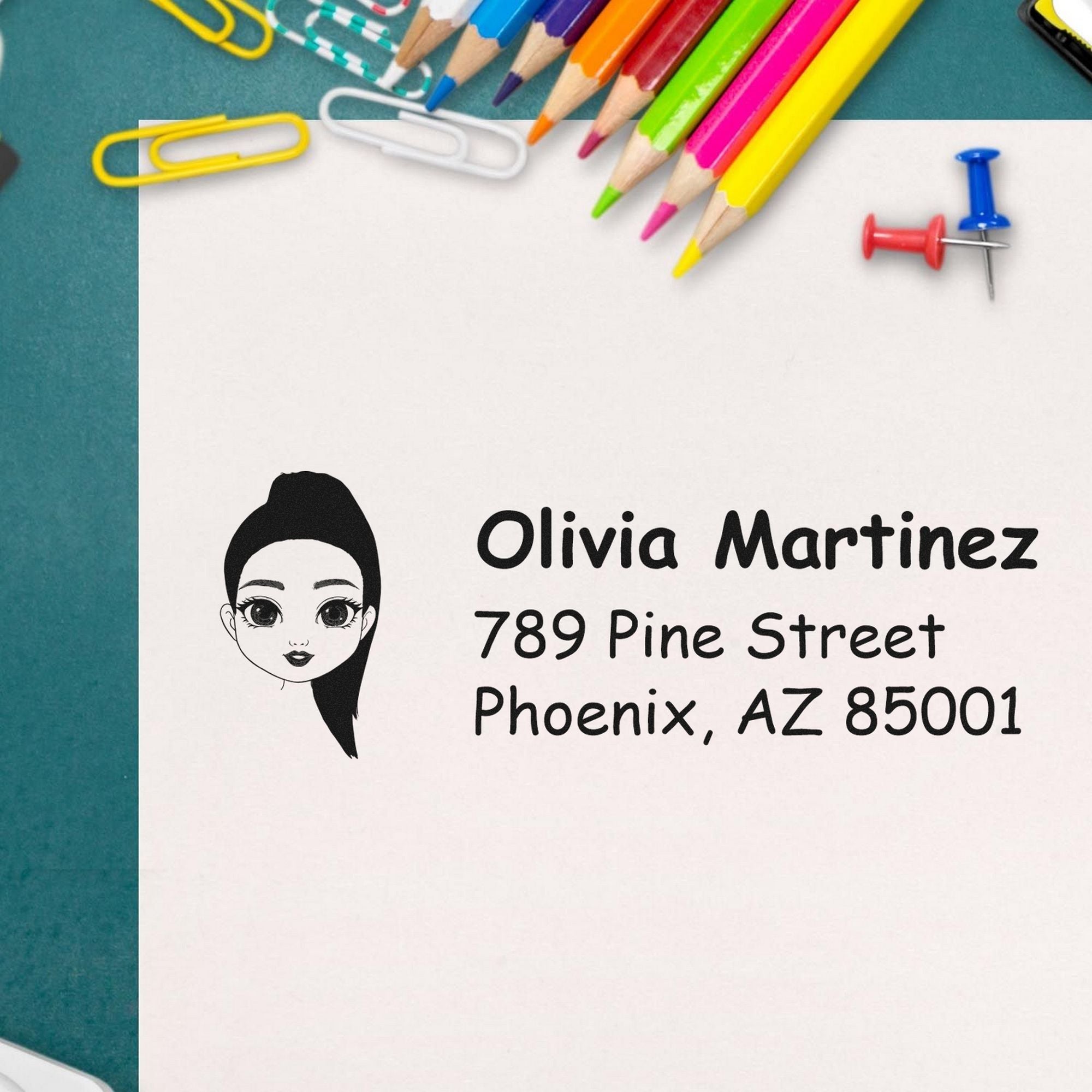 Custom address stamp and seal with cartoon woman, black text, and colorful pencils, paper clips, and push pins on teal background.