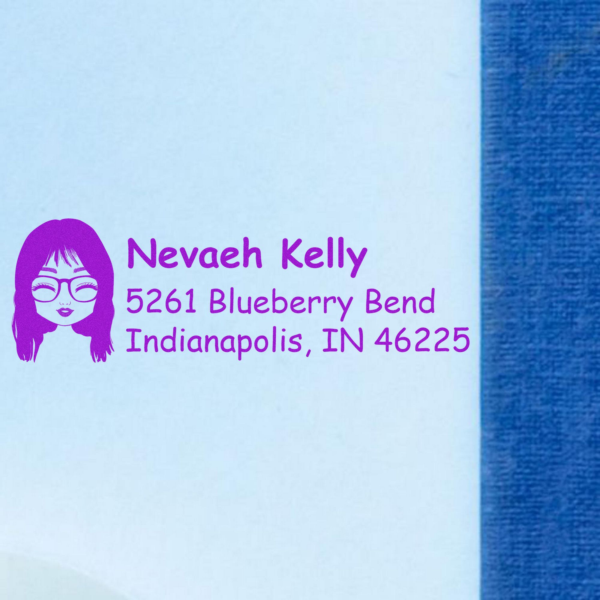 Purple self-inking address stamp with woman icon, Nevaeh Kelly, and Indianapolis, IN 46225 on white paper.
