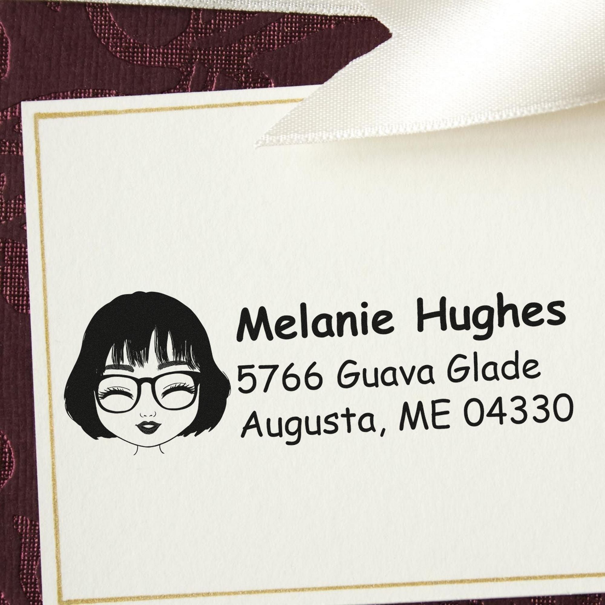 Custom stamp and seal card with black female logo, gold border, and burgundy background, labeled Melanie Hughes, Augusta, ME.