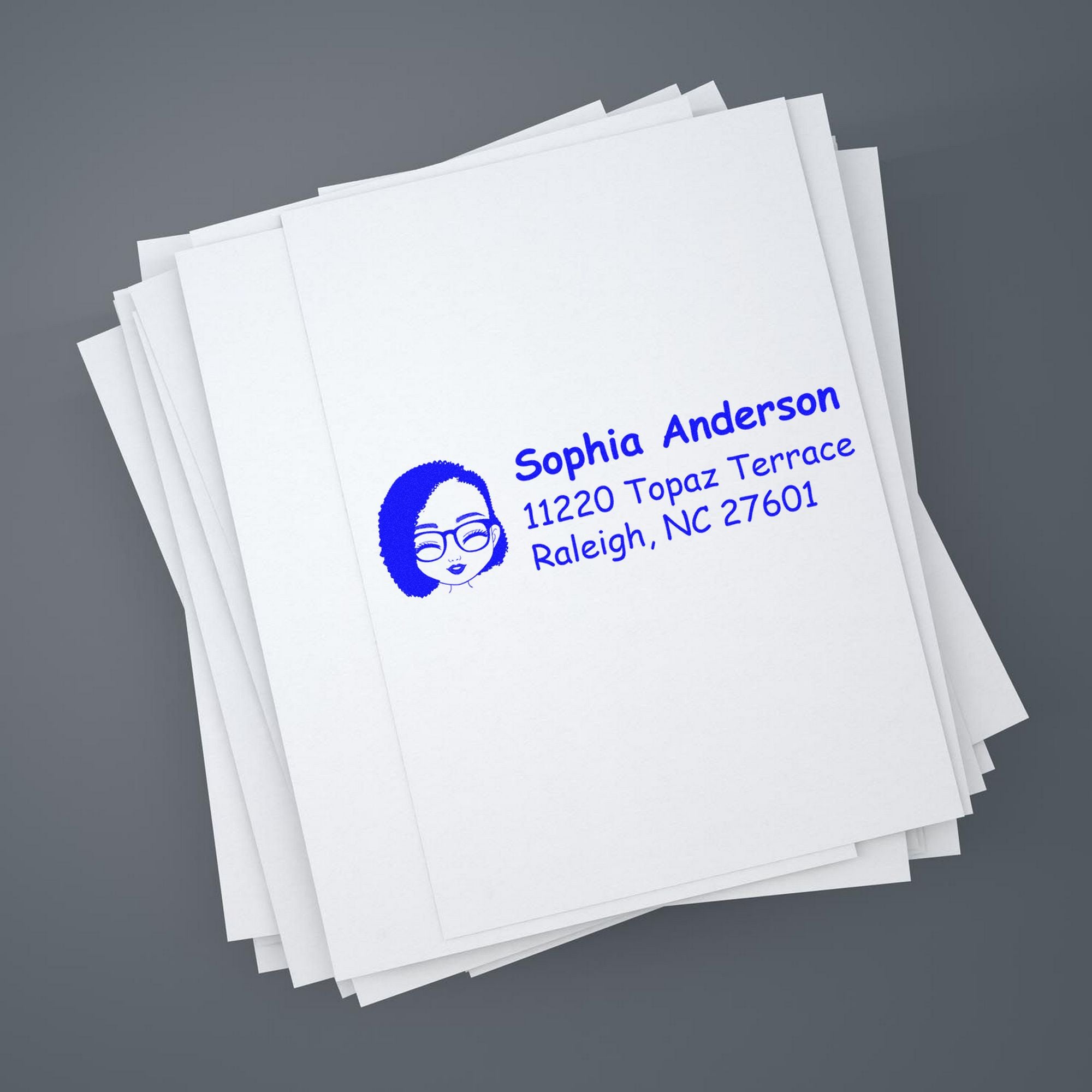 Stack of white envelopes with a blue custom address stamp and seal featuring a woman's face on a gray background.