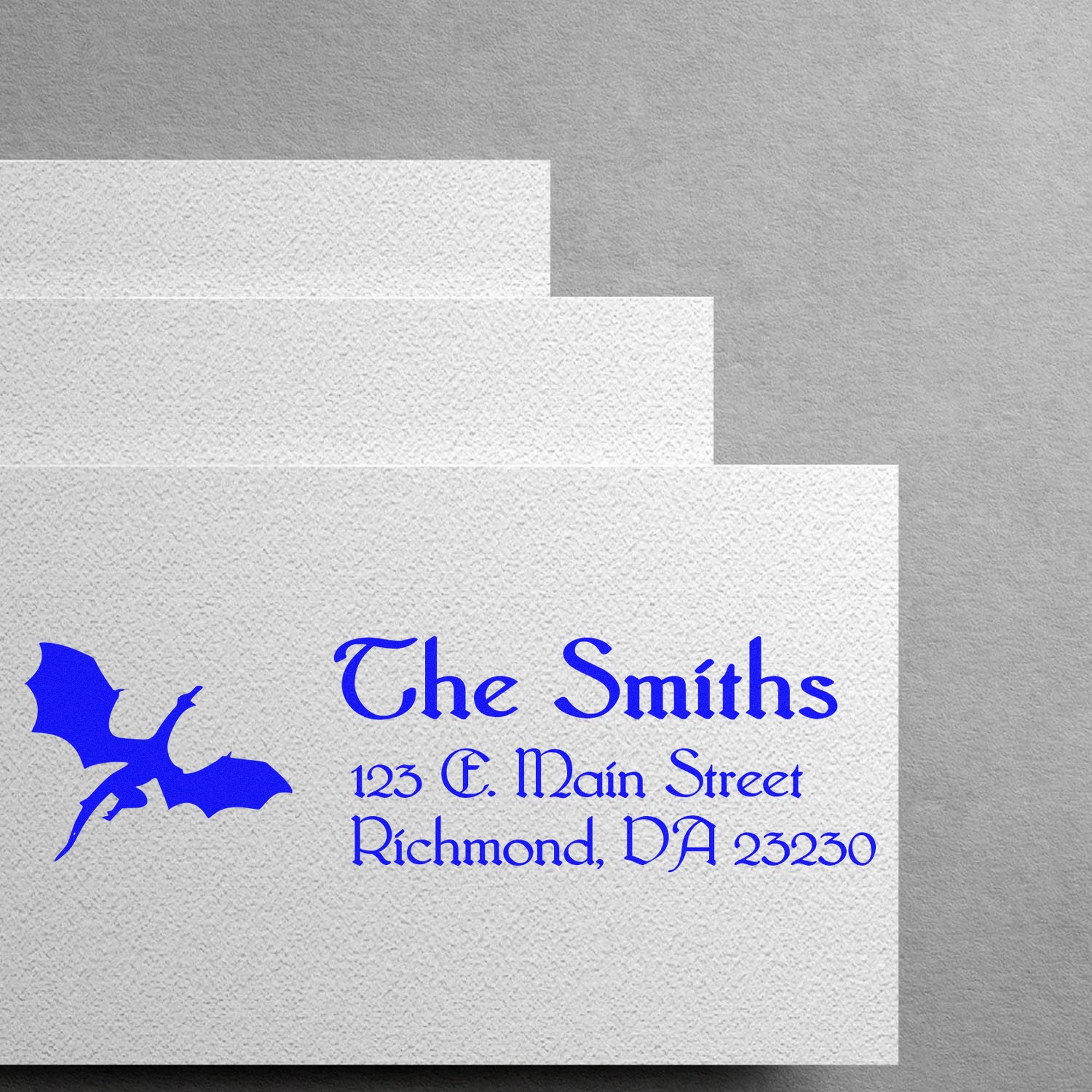 Blue custom stamp and seal samples on textured white paper, featuring a bat logo and The Smiths address.