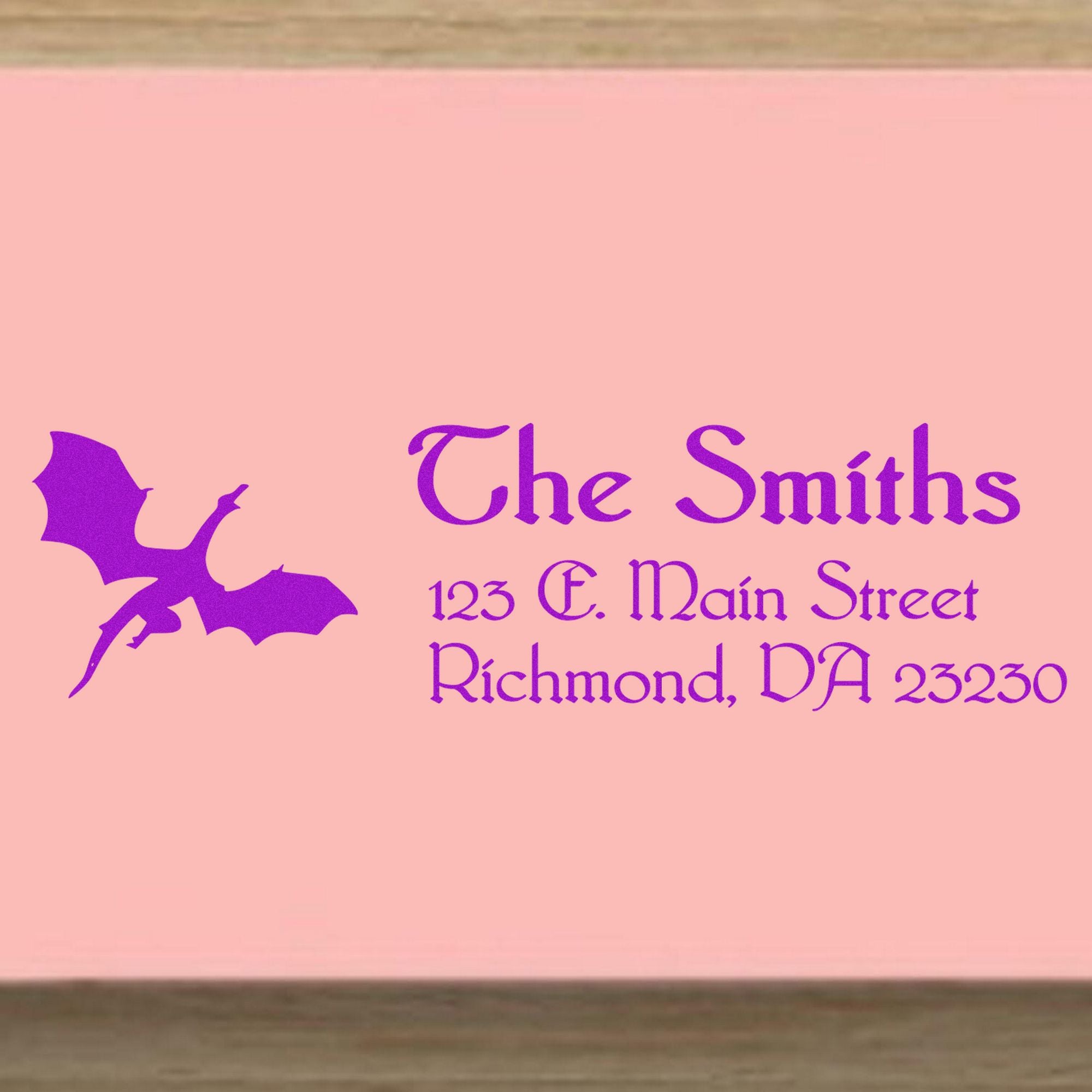 Pink custom address stamp with purple dragon logo and ornate text for The Smiths, 123 E. Main Street, Richmond, VA 23230
