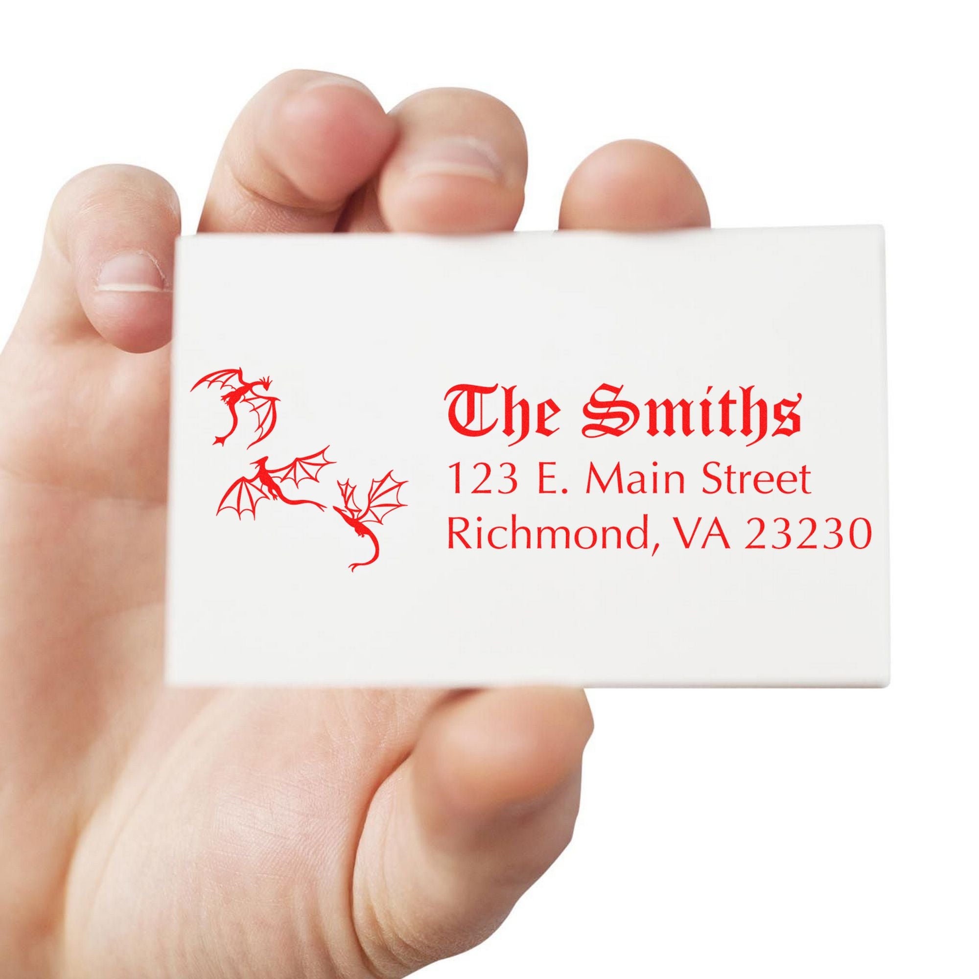 Hand holding a white business card with red dragon stamp seals and The Smiths address in gothic red text.