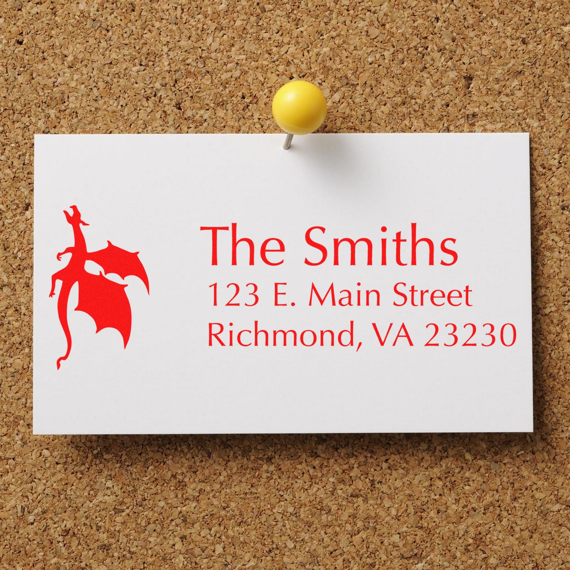 Custom red business stamp and seal card pinned with a yellow pushpin on corkboard, reading The Smiths, Richmond, VA.